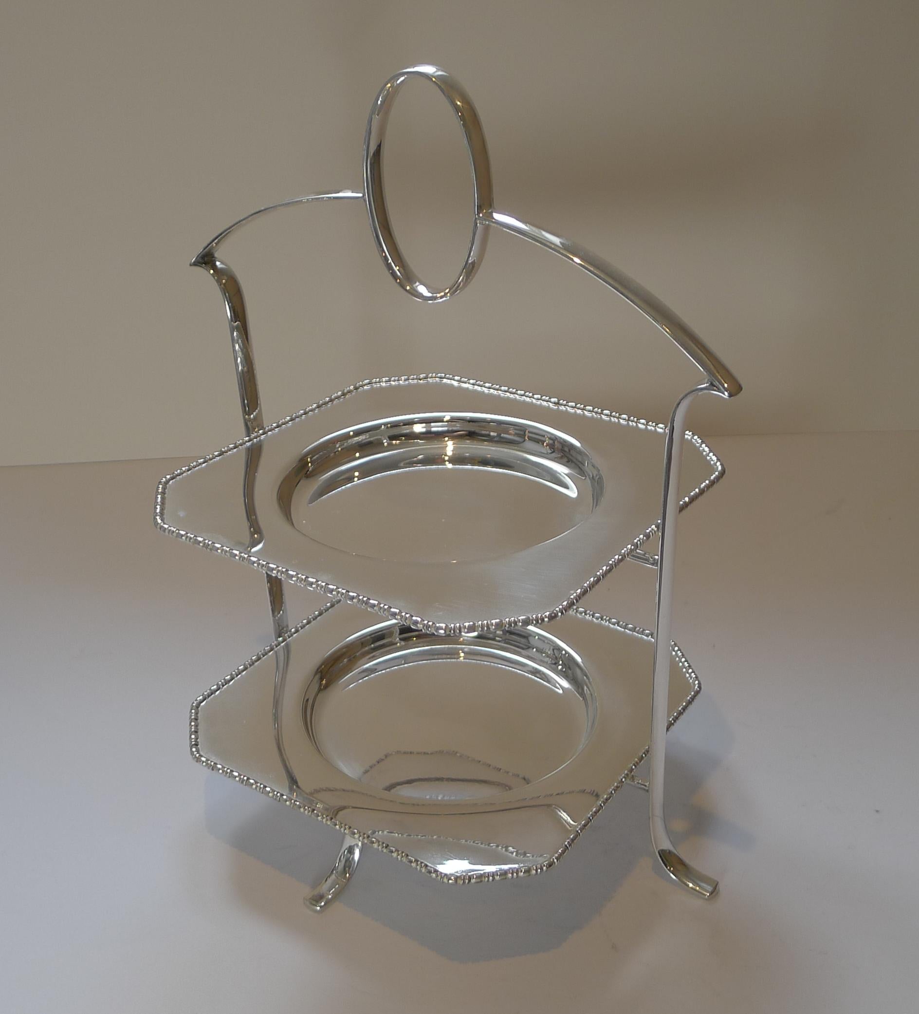 A stylish antique English cake stand in silver plate by top-notch silversmith, Deakin and Francis. 

A beautifully shaped frame with integral handle is complimented by two square cake plates, each with a lovely raised border.

Excellent