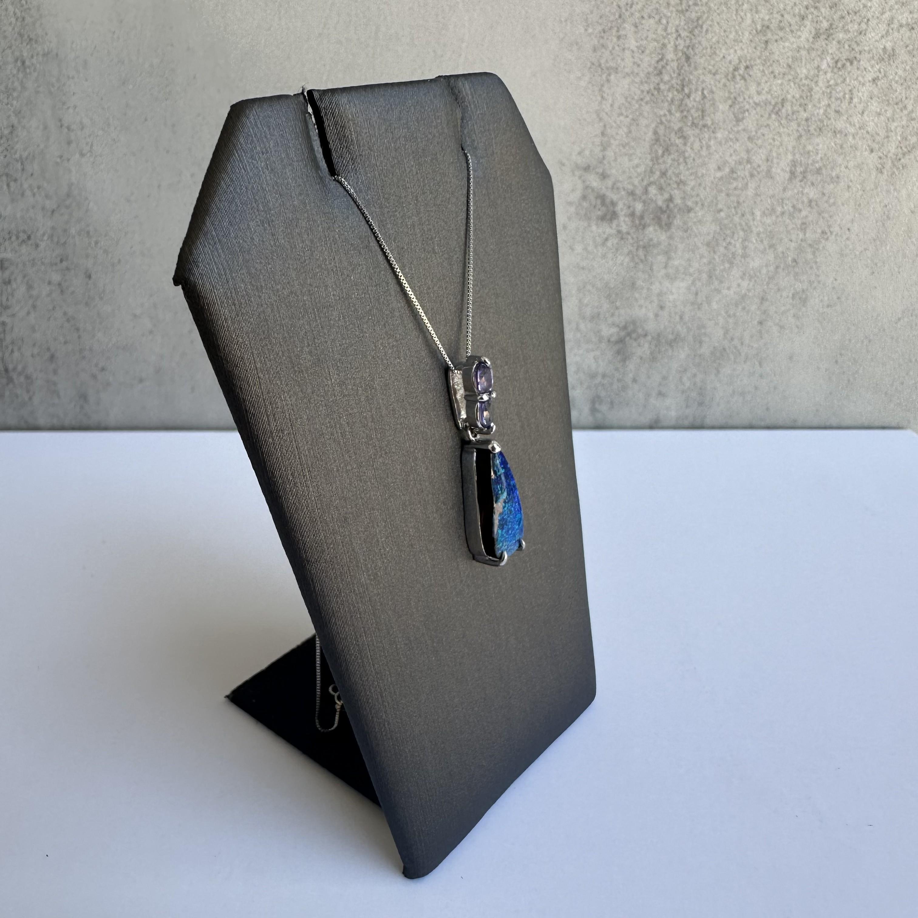 Indulge in the exceptional elegance of this Platinum Opal and Amethyst Necklace, a masterpiece of fine jewelry. Featuring a stunning 2.38ctw blue opal doublet complemented by 0.40ctw of vibrant amethyst, this necklace is set in a luxurious PT900