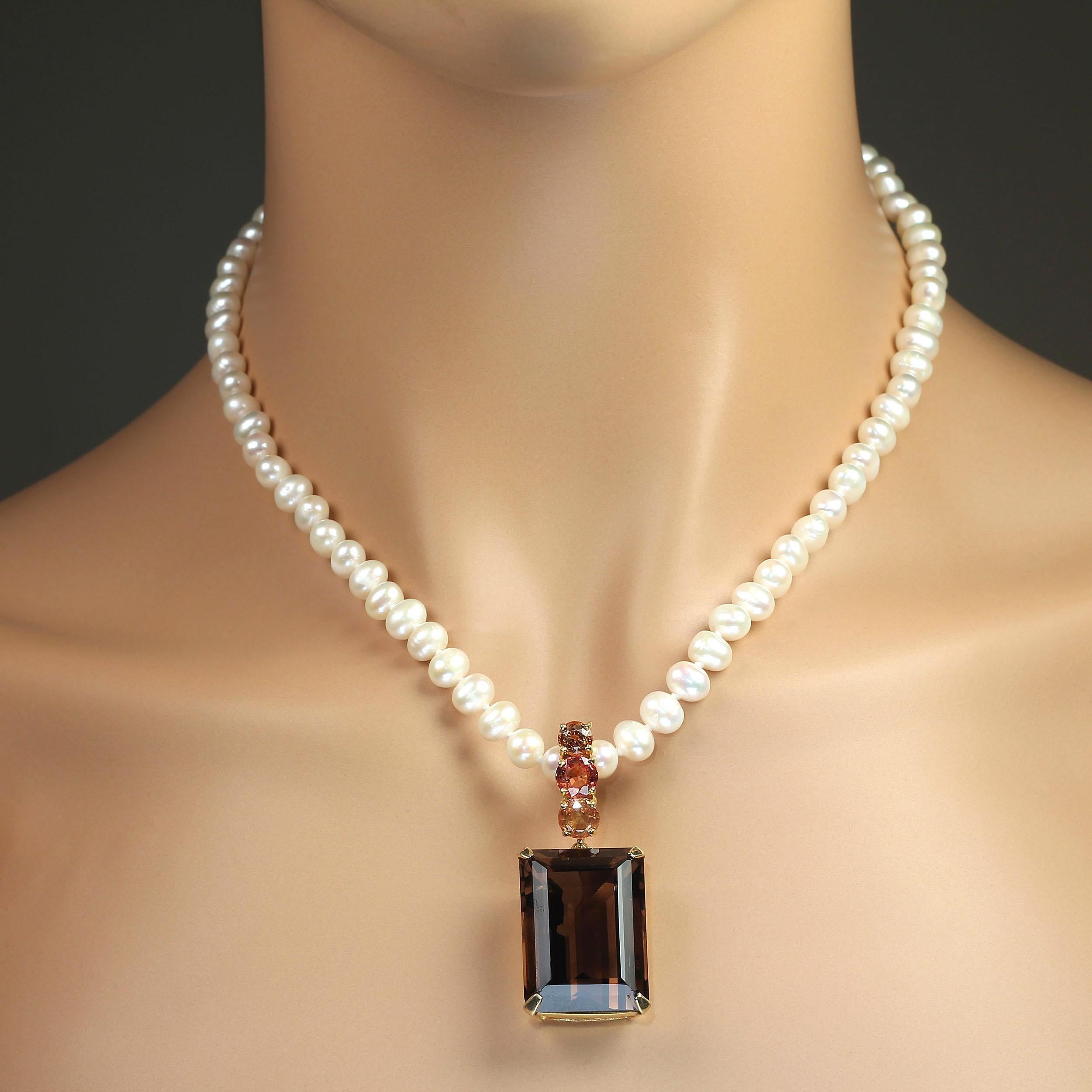 Elegantly large evening pendant of Smoky Quartz topped with peachy/orange Sapphire on a hinged bail. This pendant will easily work with your pearls, scarves, and chains because of the hinged bail. The gold rhodium over Sterling Silver setting is