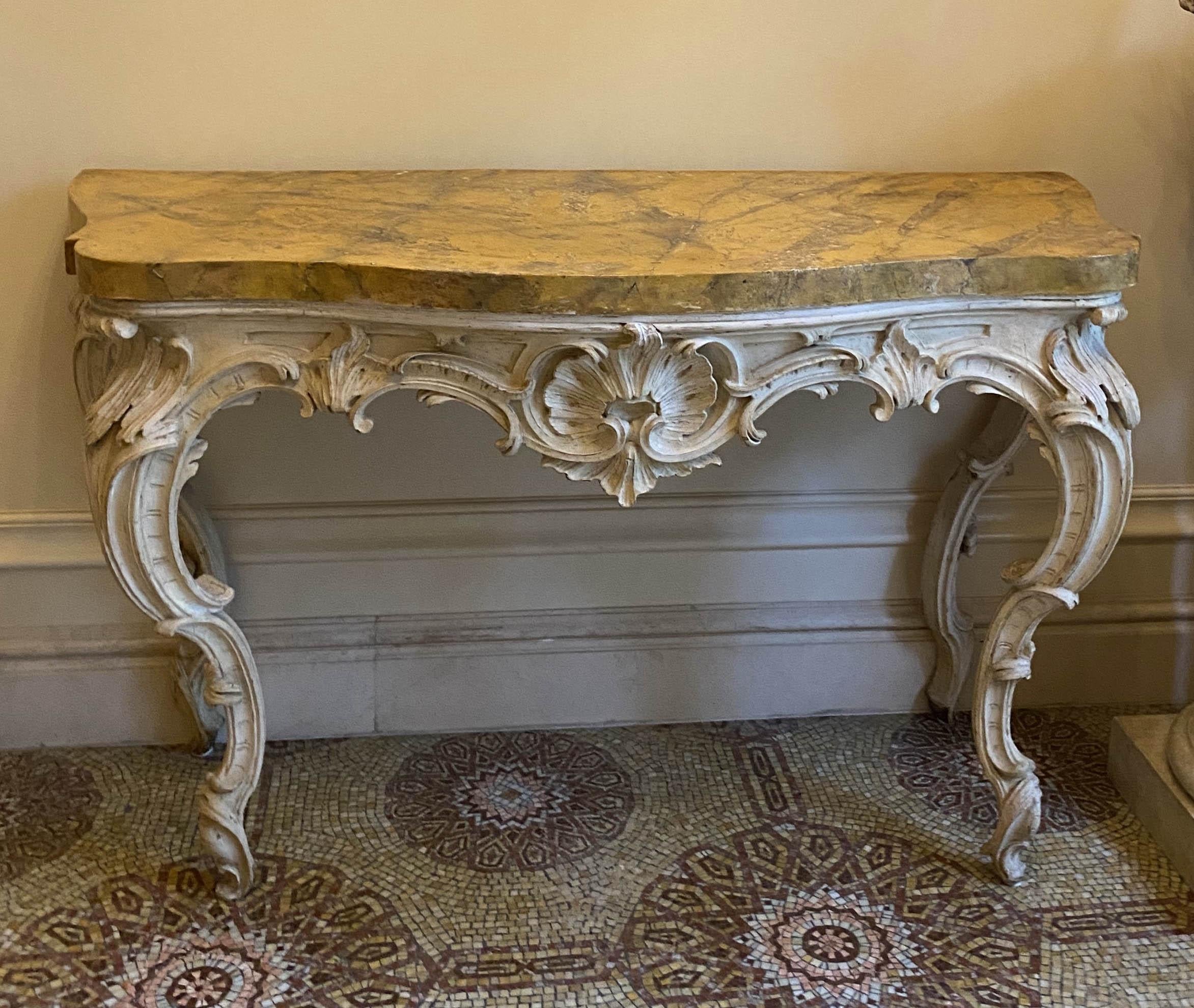 Finely carved Italian 18th century ivory painted console tables with a Siena Marble painted scalgliola top.
Originally the table was gilded.
Very good vintage condition.
 Proveniance from a Roman aristocratic estate.