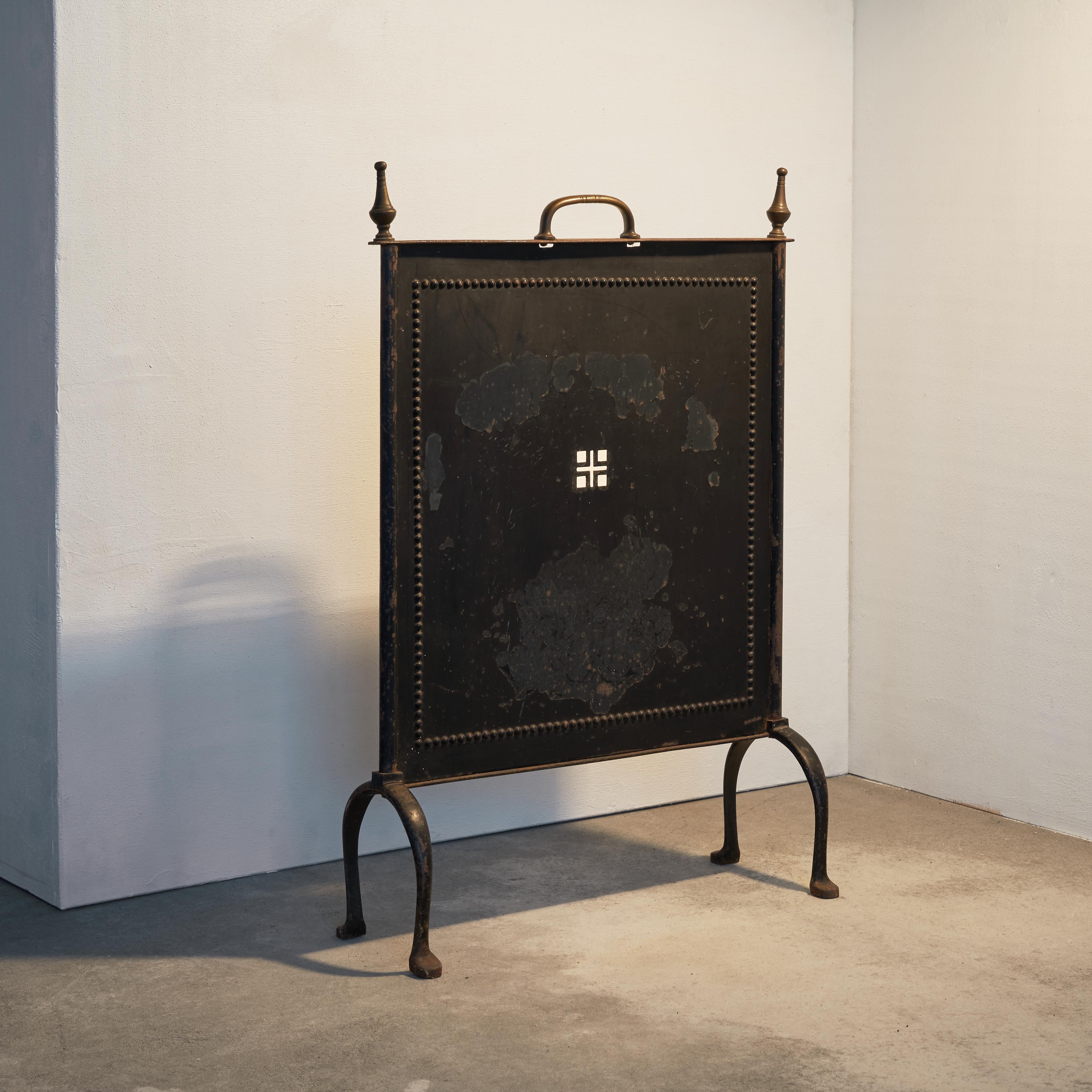 Beautifully elegant fireplace screen in metal and brass. First half of the 20th century.

This is a classic piece with a modern and refreshing allure. The fire screen is simple in shape, but still looks rich because of the brass details. The legs,