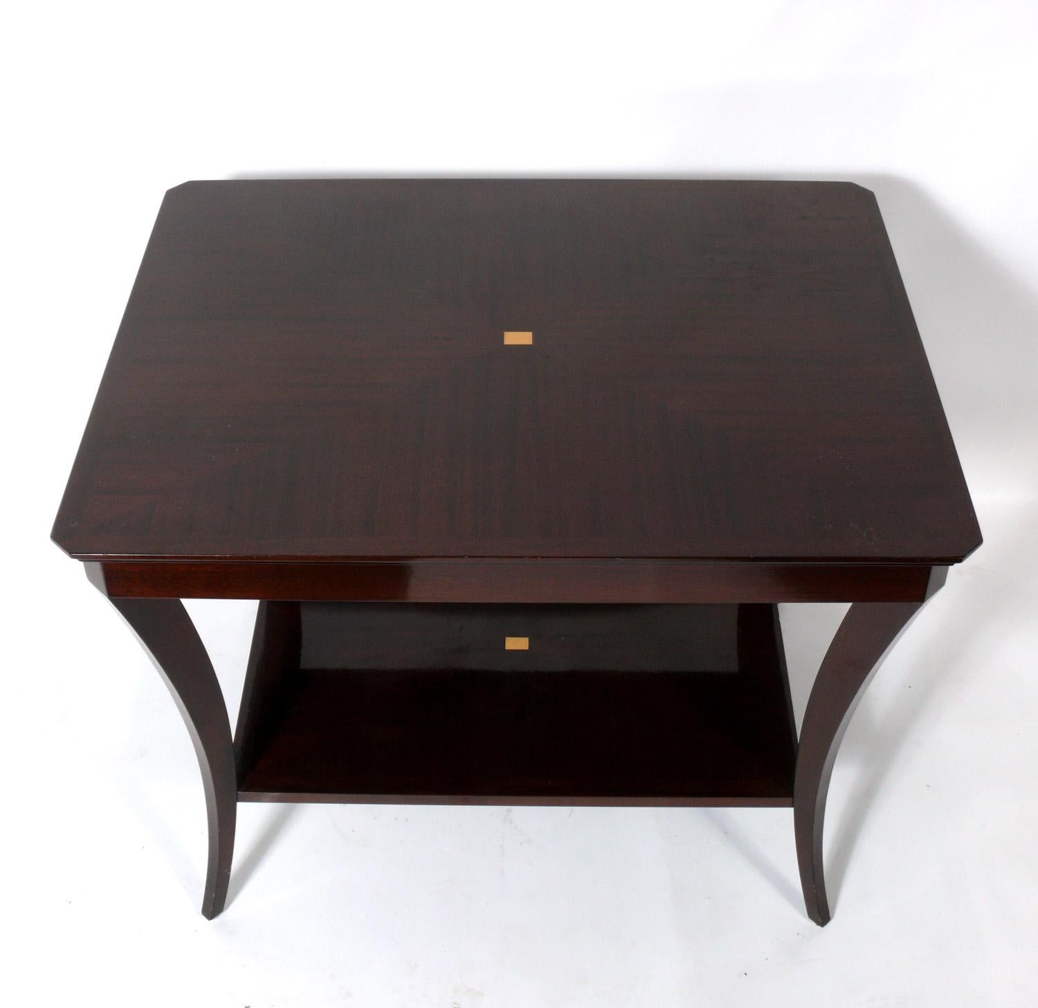 Elegant flared leg table in the manner of Tommi Parzinger, American, circa 1990s. Beautifully grained wood with contrasting inlay. It is a versatile size and can be used as a center table, end or side table, or night stand.