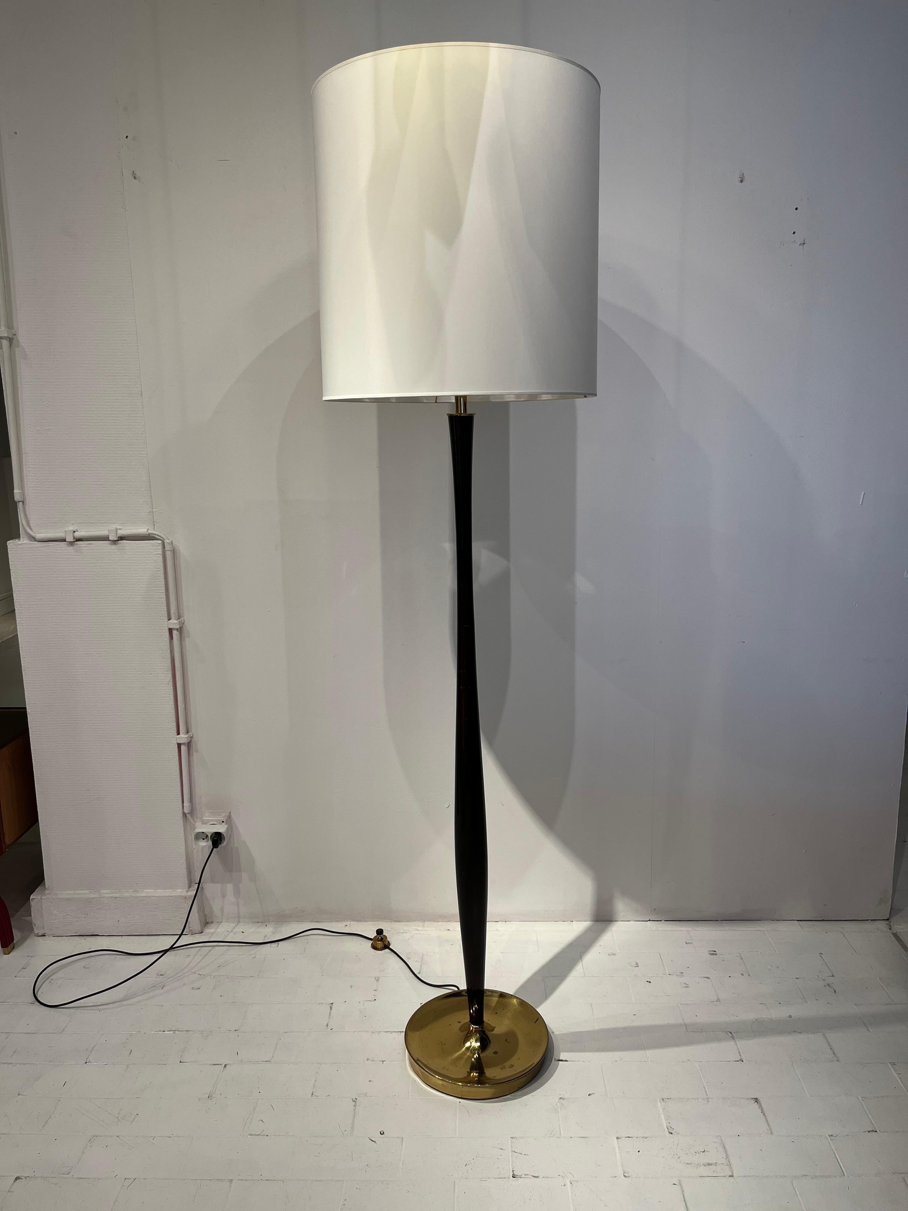 Elegant lacquered walnut and brass Stilnovo floor lamp. The lamp dates from the 1950s. The design of this floor lamp is particularly interesting. The cylindrical stem is softly widening towards the base. This simple abstraction gives a sculptural