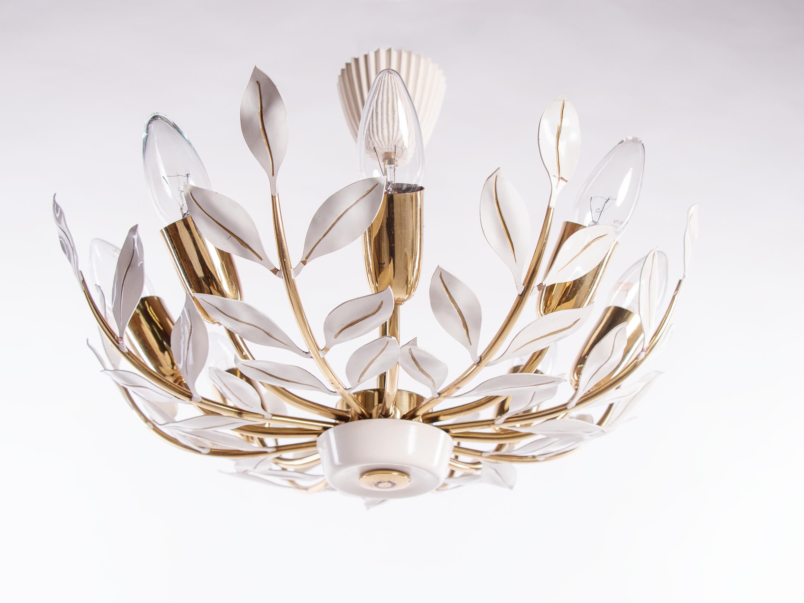 Elegant chandelier with 8 arms executed in brass and metal with white painted metal leaves. 
 
Manufactured by Vereinigte Werkstätten Munich in Germany in the 1950s. 
 
Measures: diameter 17.7