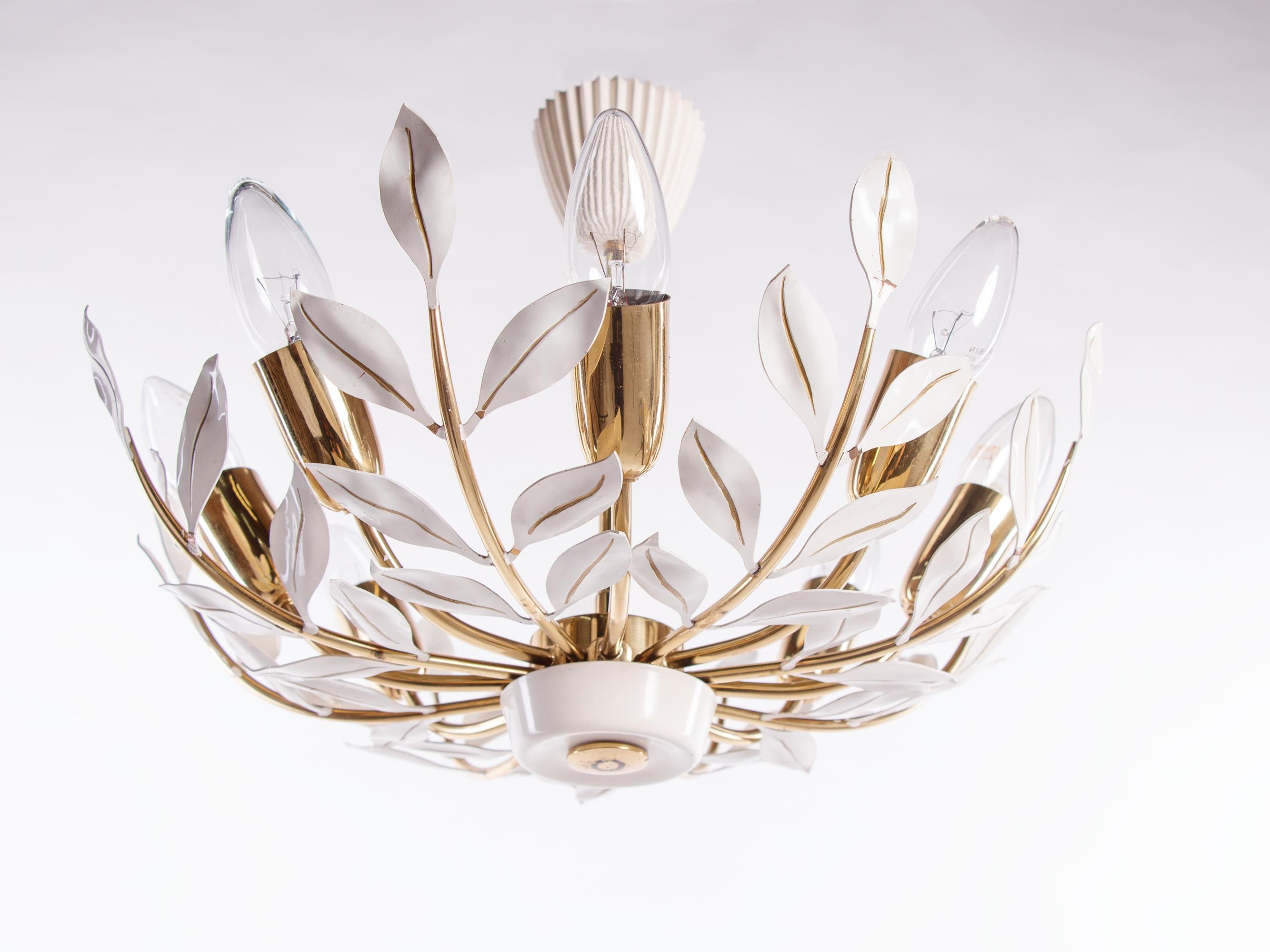 Elegante lampadario a 8 bracci realizzato in ottone e metallo con foglie in metallo verniciato bianco. 
 
Prodotto da Vereinigte Werkstätten Munich in Germania negli anni '50. 
 
Misure: diametro 17,7