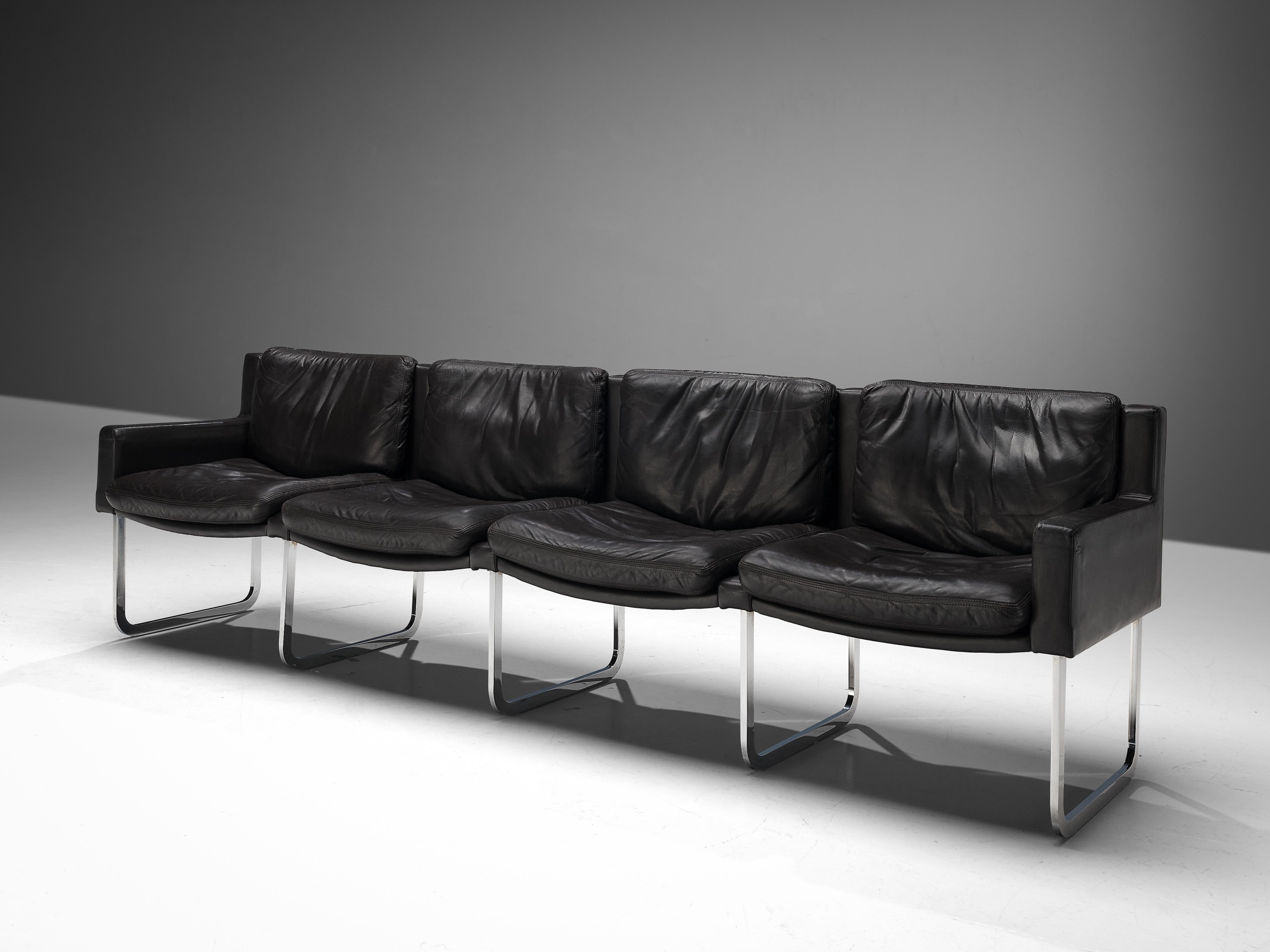 Sofa, black leather, steel, Europe, 1970s

A well-composed sofa with comfortable cushions and a sleek appearance. The designer created a large sofa that rests on four flat, U-shaped legs. They are contrasting with the black leather seats which are