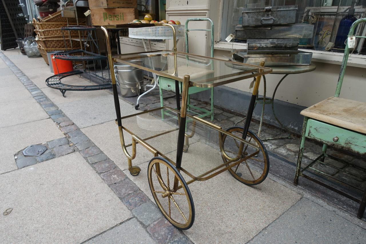 Elegant 1930s serving cart / drinks trolley, from France. Brass frame, large wheels, wooden cladding on the frame and handles. Original glass shelves. Super item and quality piece.