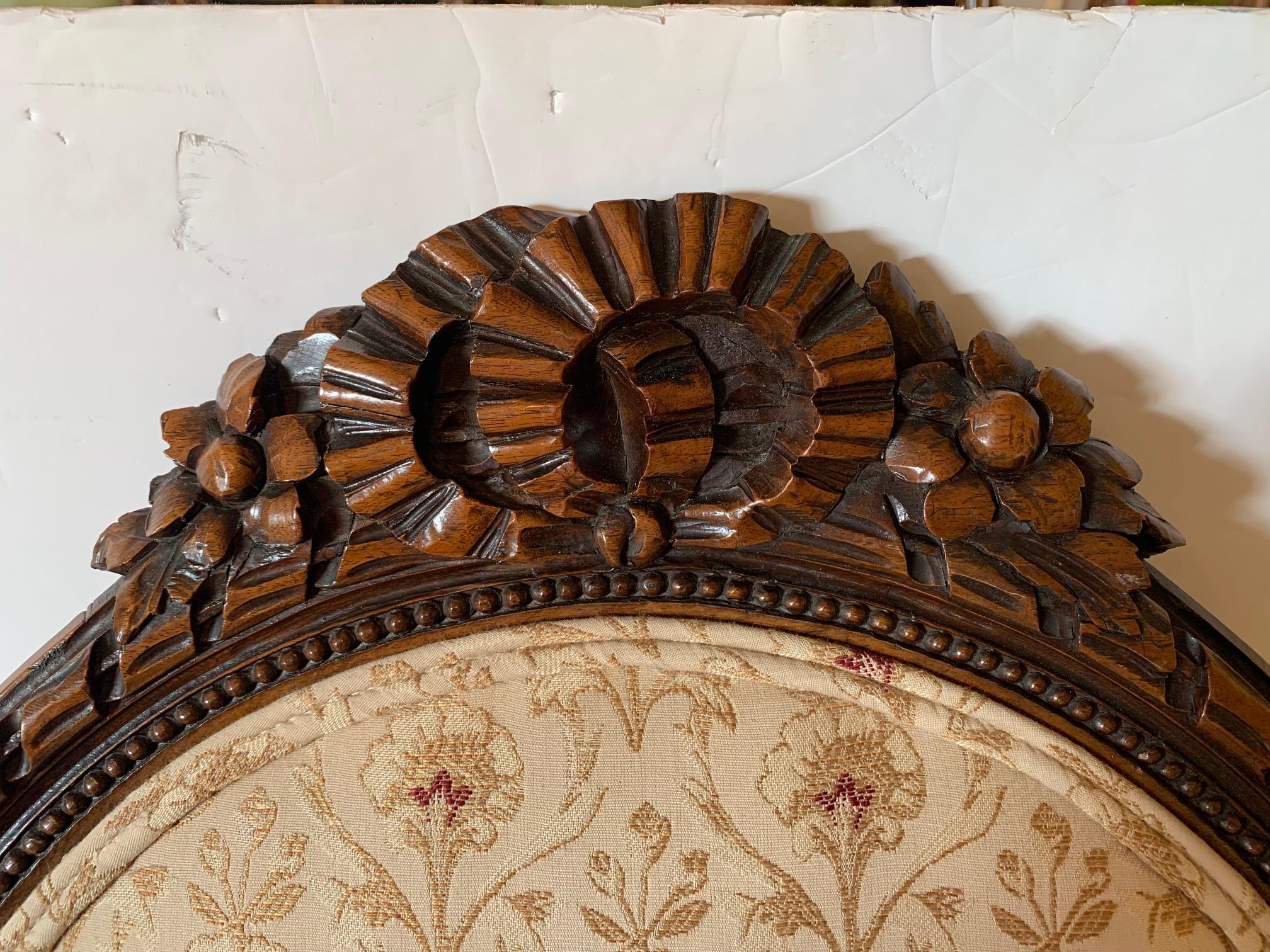 Old world charm is found in this French antique armchair and round ottoman set, having romantic carved walnut with acanthus leaves and wreath like forms at the top, reeded tapered legs, oval back and round ottoman.
Ottoman 
16” W x 14” D x 9.5”