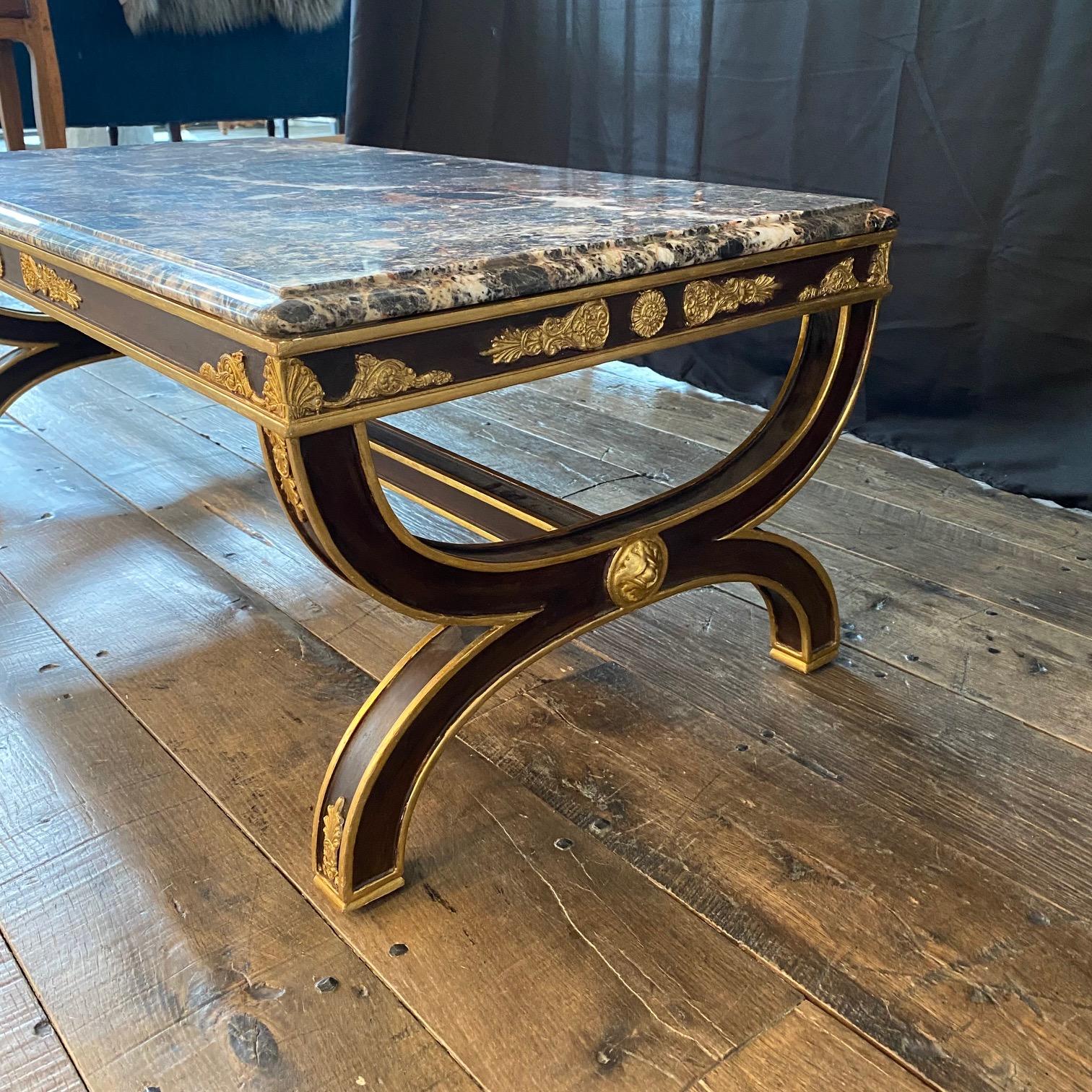 A beautiful and impressive antique French marble top coffee table having  ebony with gorgeous gilt mounts highlighting the lovely circular side stretchers pattern. The heavy rectangular marble top has wonderful color and patterns and sits loose on