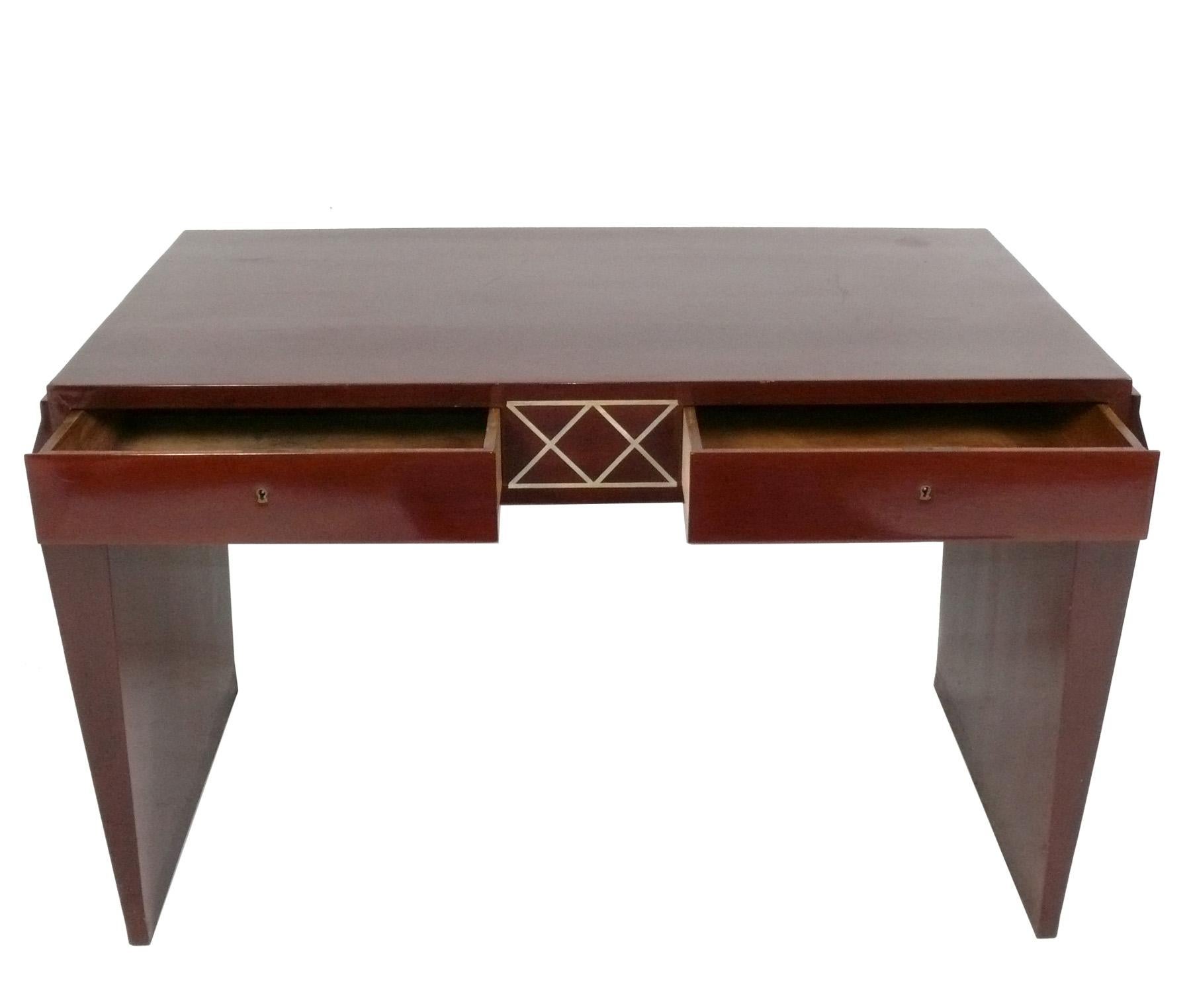 Elegant French Art Deco Desk, France, circa 1930s. Stylish tapered leg form with geometric inlaid design between the drawers. Two deep locking drawers provide ample storage and it retains the original key.