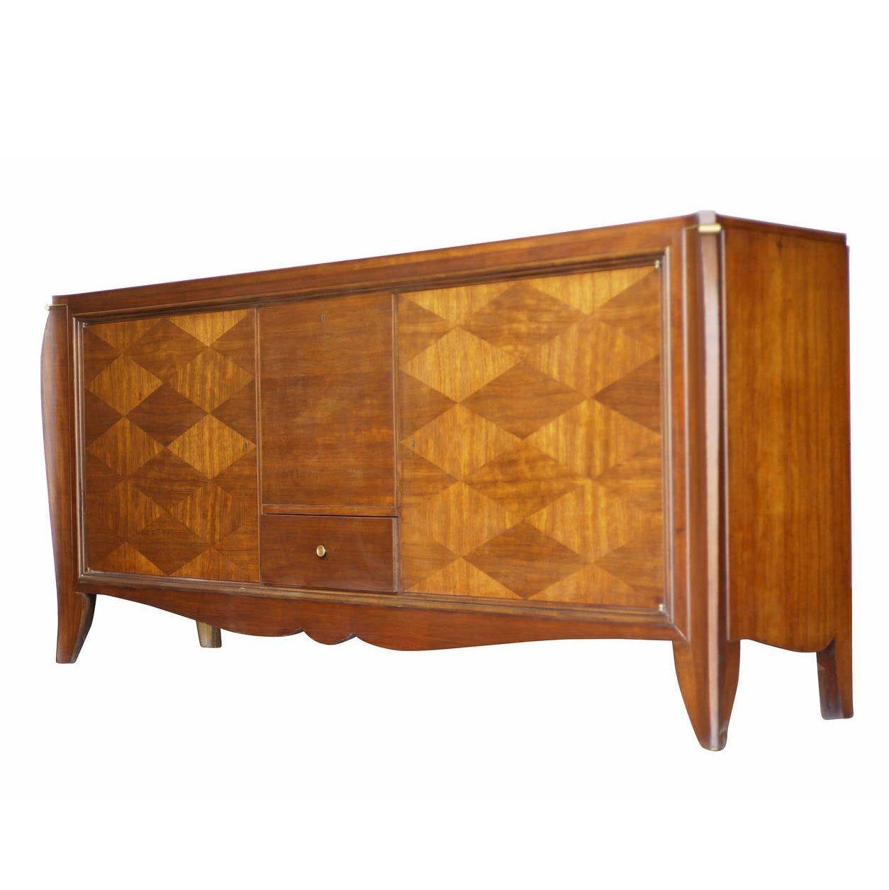 A beautiful French Art Deco Djo Bourgeois style sideboard with medium stain diamond pattern and wood inlay with elegantly tapered legs. The sideboard features 3 storage cabinets and a single pullout / pull-out drawer in the center each with hand