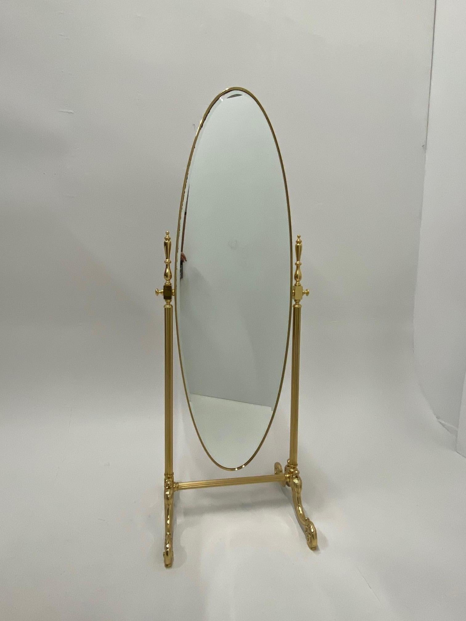 An elegant oval solid brass full length Cheval mirror having very pretty base and reeded brass stand.