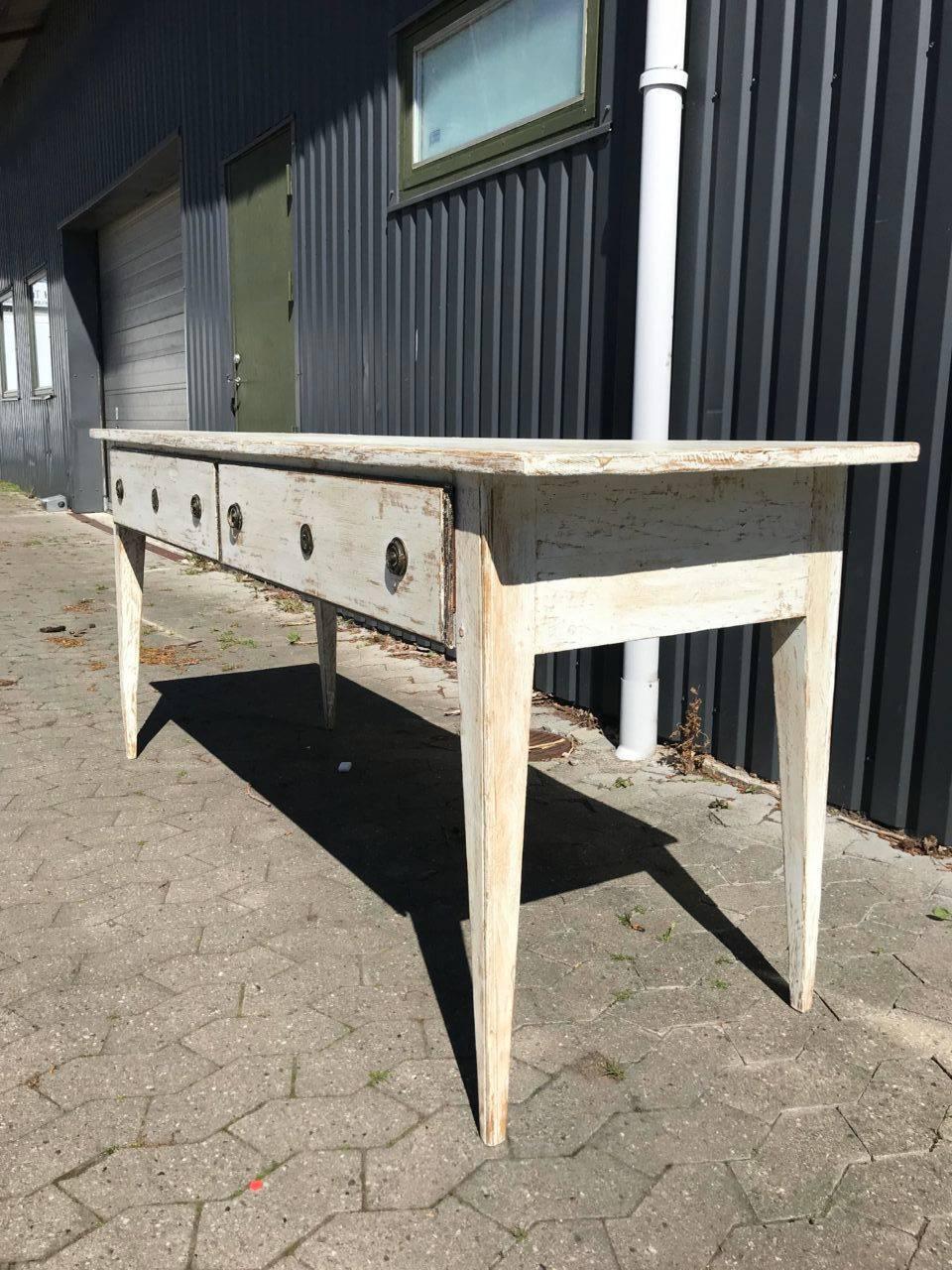 Charming vintage French console table, Louis XVI style, with lovely groovework in the tapered legs. There are two drawers, with charming round handles, and had been painted a gorgeous creamy white shade. Super patina. An attractive and practical