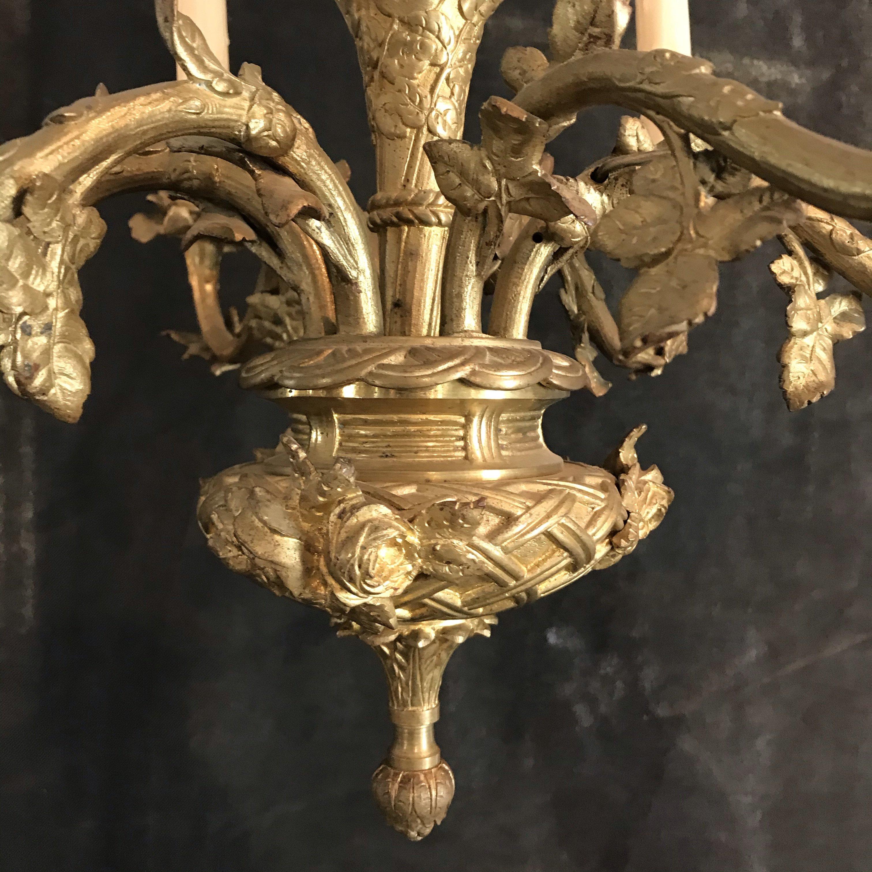 A lovely French gold gilt bronze 6-arm chandelier having floral bobeshes and leafy decoration. Rewired for the US!


    