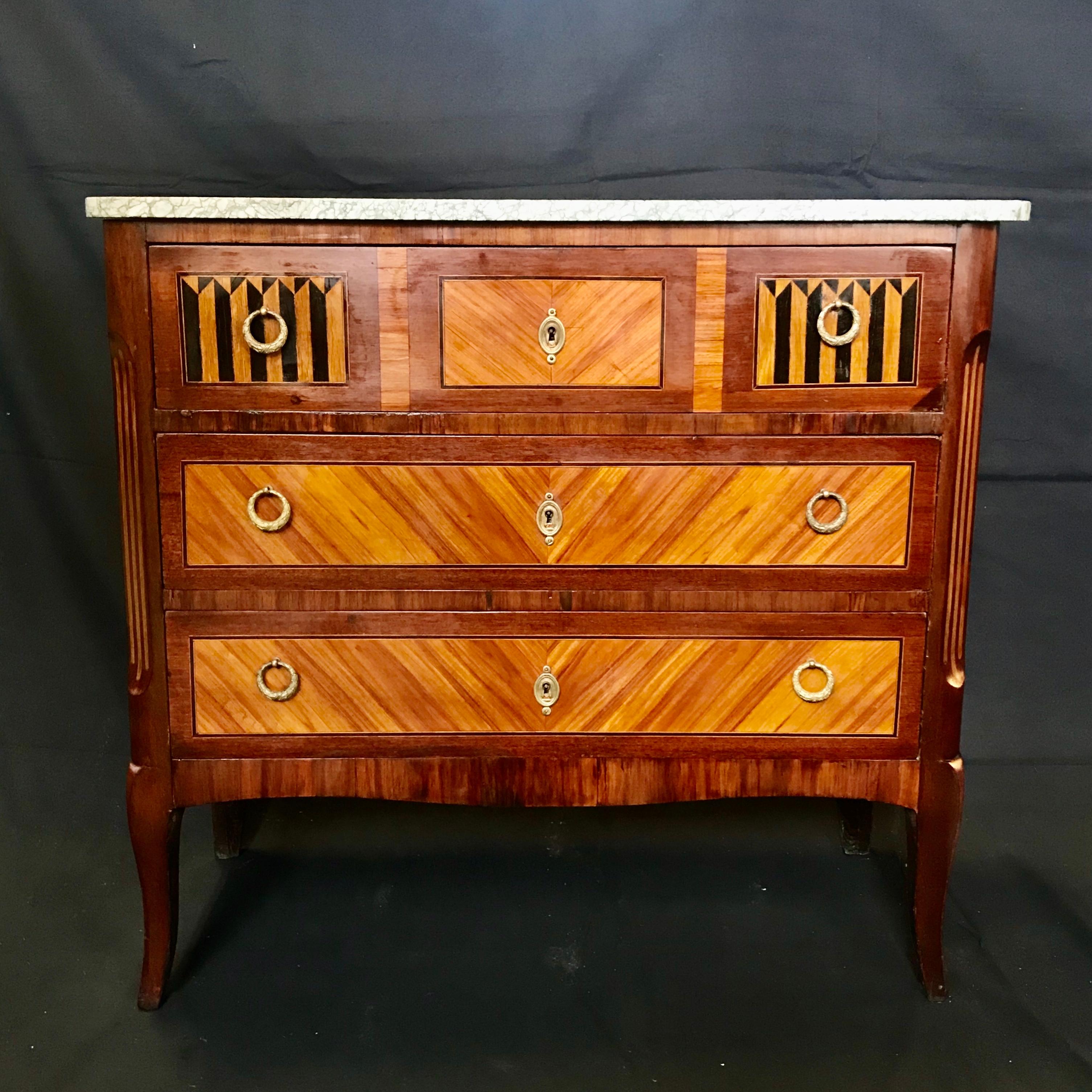 Absolutely beautiful walnut French Louis XVI style marquetry inlaid petite commode with marble top and intricate ebony inlay. Original brass hardware.
#4275.
 
