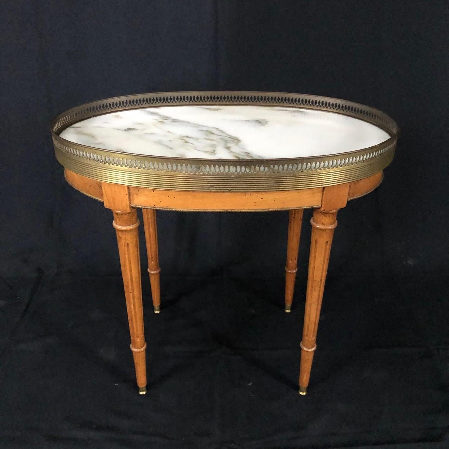French Louis XVI style light oak side table having beautiful Carrara marble top and brass gallery over reeded tapered legs terminating in brass capped feet.
#5154.