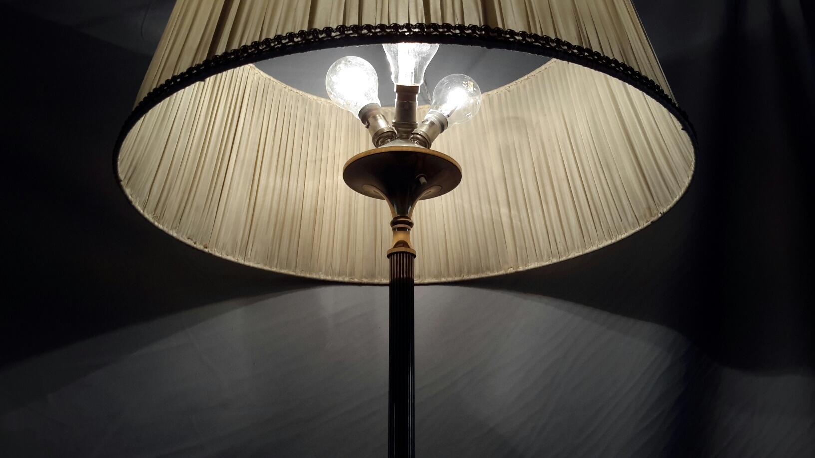 Très élégant lampadaire à trois lumières des années 1950 fabriqué par la Maison Arlus en bronze avec base tripode patinée noire et cannelure noire pour l'axe. Elle est munie d'un abat-jour en coton plissé.
La patine du plancher de la lampe est en