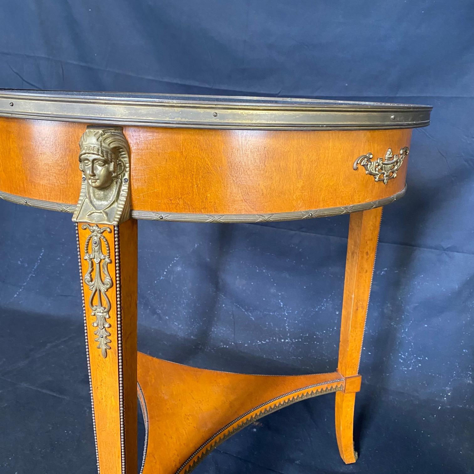 Lovely details in this French Neoclassical style round side table having beautiful green marble top over tapering legs capped with bronze jabots.  Figural busts in bronze add to the embellishmensts, and there's beaded trim as well as fretwork on the
