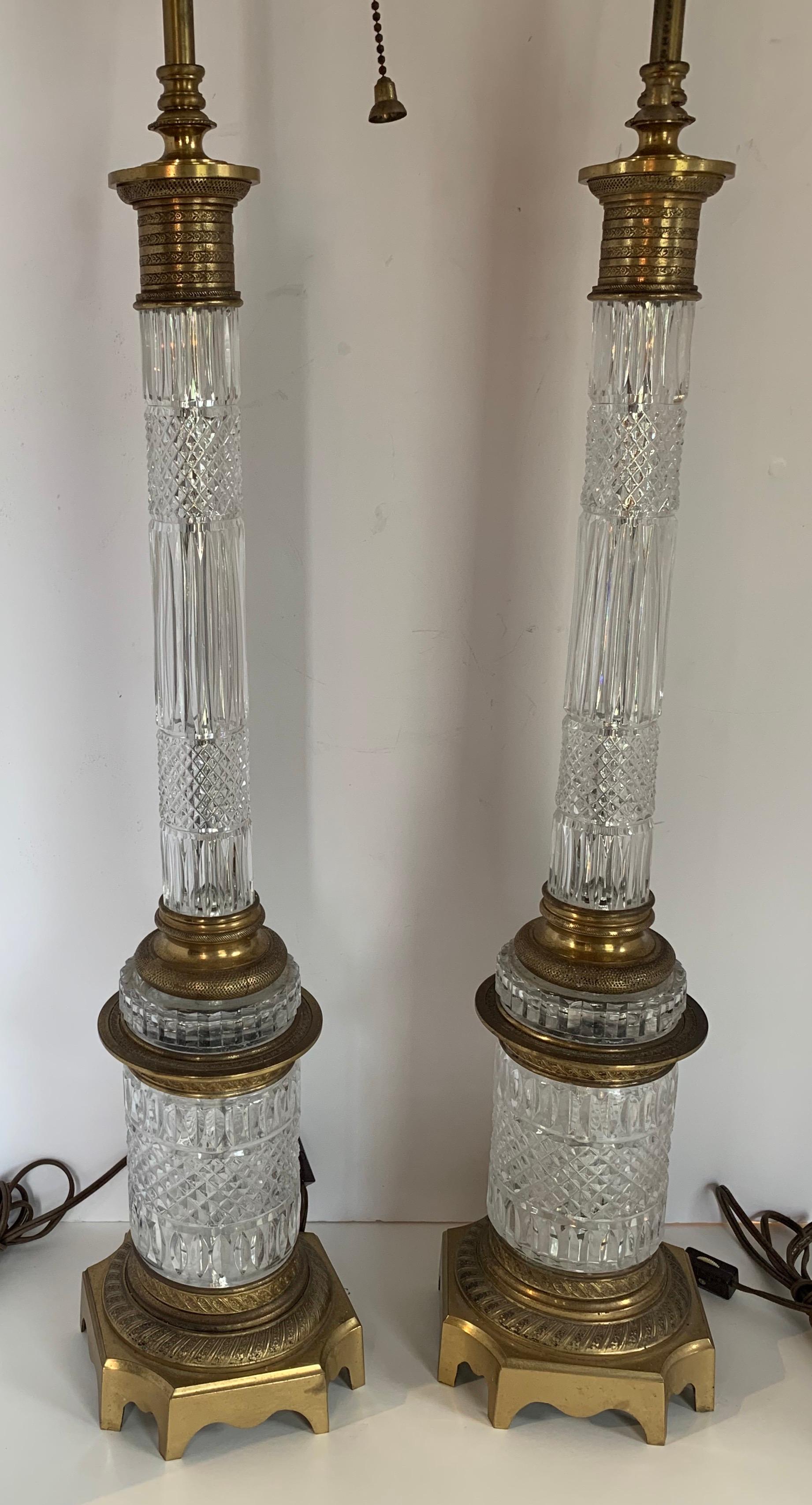 An elegant French pair of gilt doré bronze and cut crystal ormolu column neoclassical lamps with @ Edison Lights Each, In the manner of Baccarat
