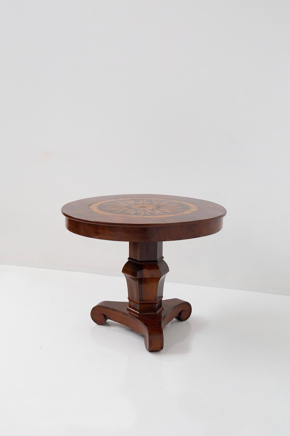 Presenting an elegant and antique French round table, dating back to the 1800s. This remarkable piece exhibits exquisite and valuable features that add a touch of sophistication to any space.
The round table top showcases intricate inlays in