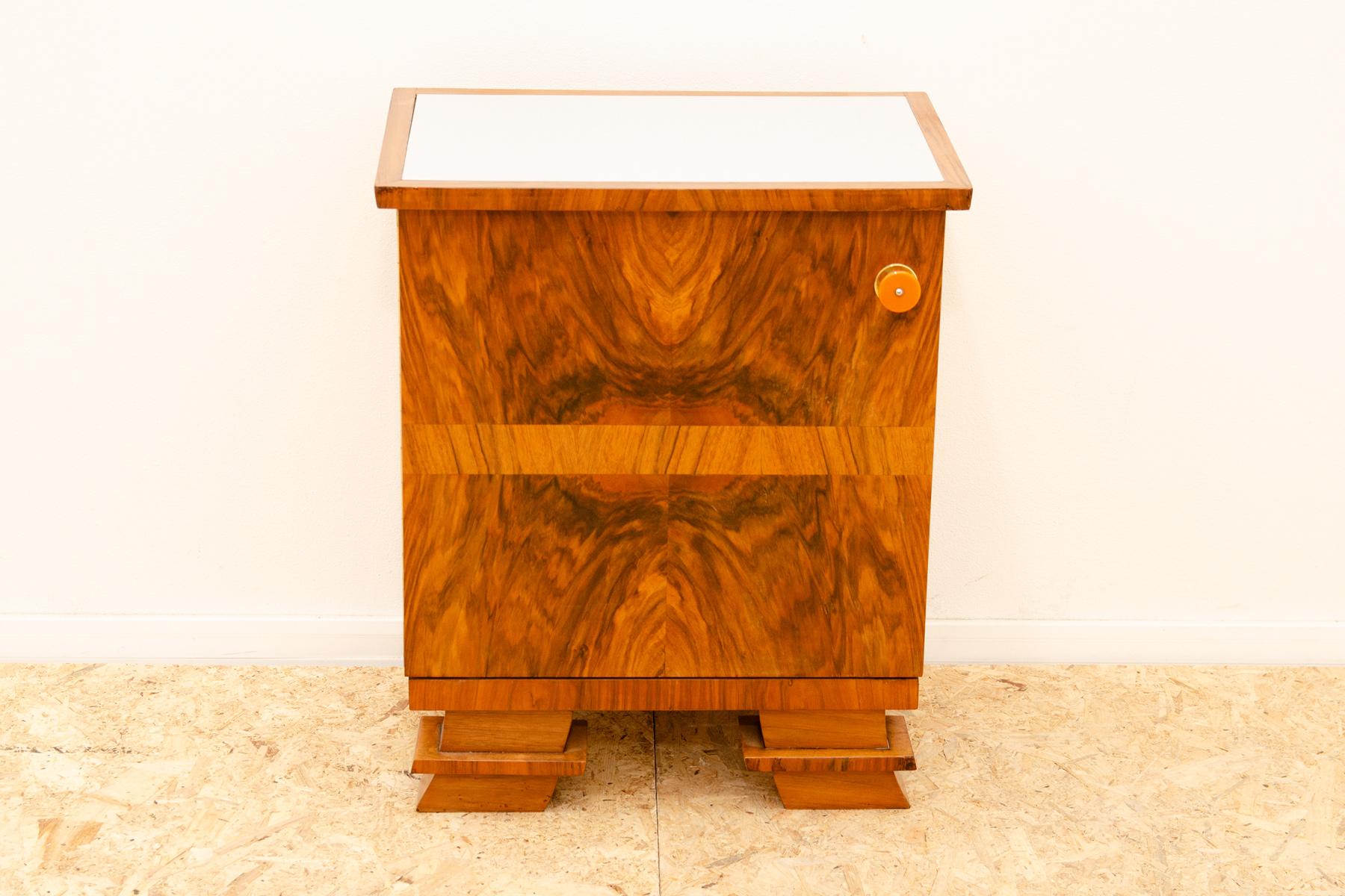 Thois ART DECO style night stand in polished walnut was made in the 1930´s. It features a very simple and practical design. It´s a nice example of Central European functionalist furniture design. It´s made of walnut wood and the white glass on the