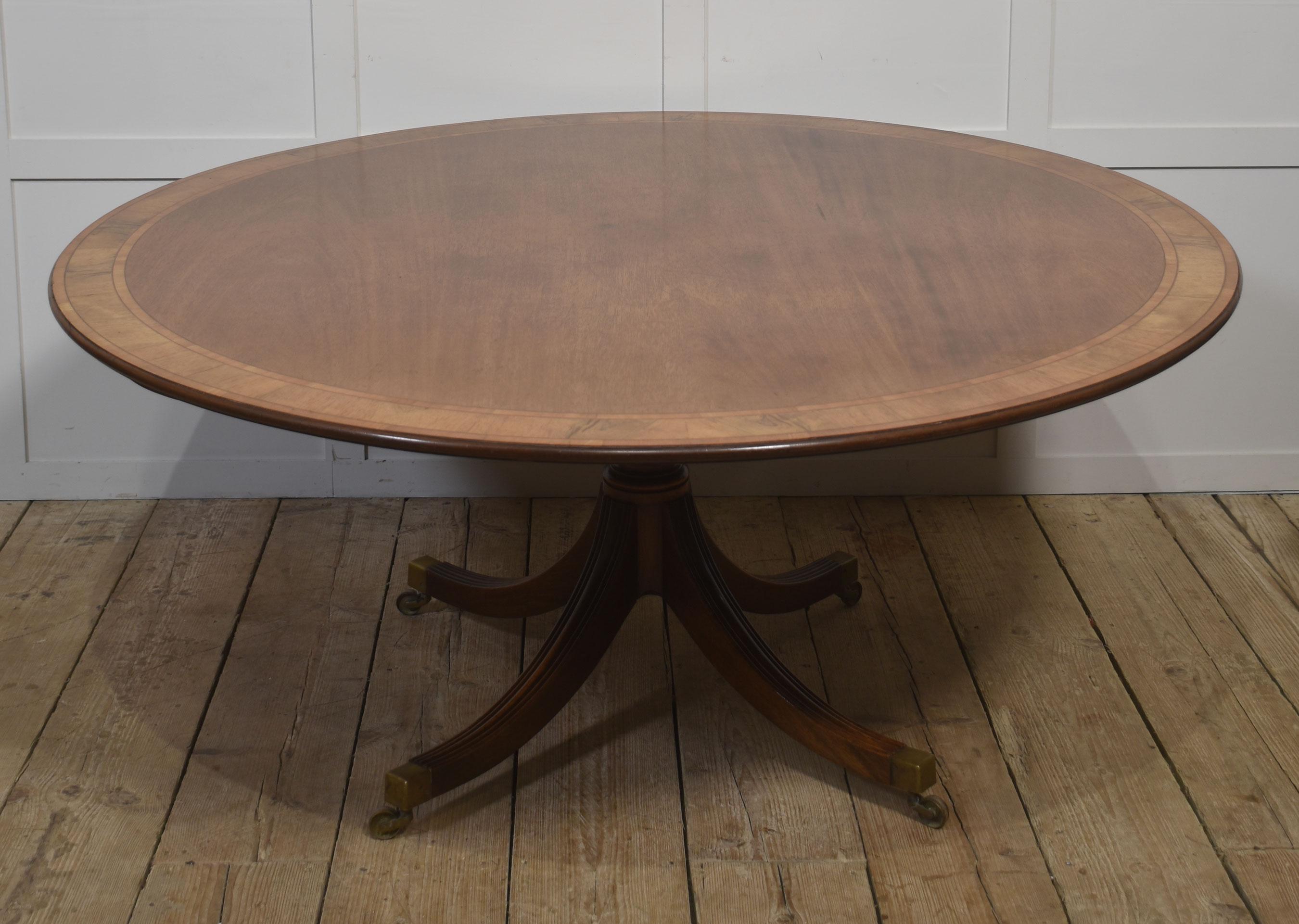 Cette table de salle à manger ronde de style géorgien magnifiquement travaillée présente un riche plateau en acajou encadré d'une remarquable bordure à bandes croisées. Les tons chauds de l'acajou se marient gracieusement avec le grain plus sombre