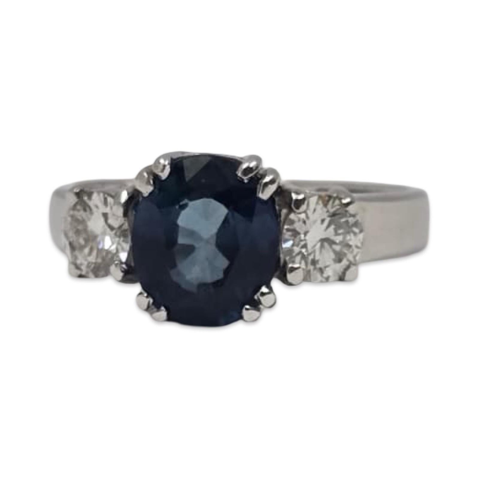 Élégante bague en or blanc 18 carats sertie d'un saphir bleu chauffé certifié GIA flanqué de deux diamants ronds presque incolores.
Le rapport de certification de la GIA est inclus dans l'achat.