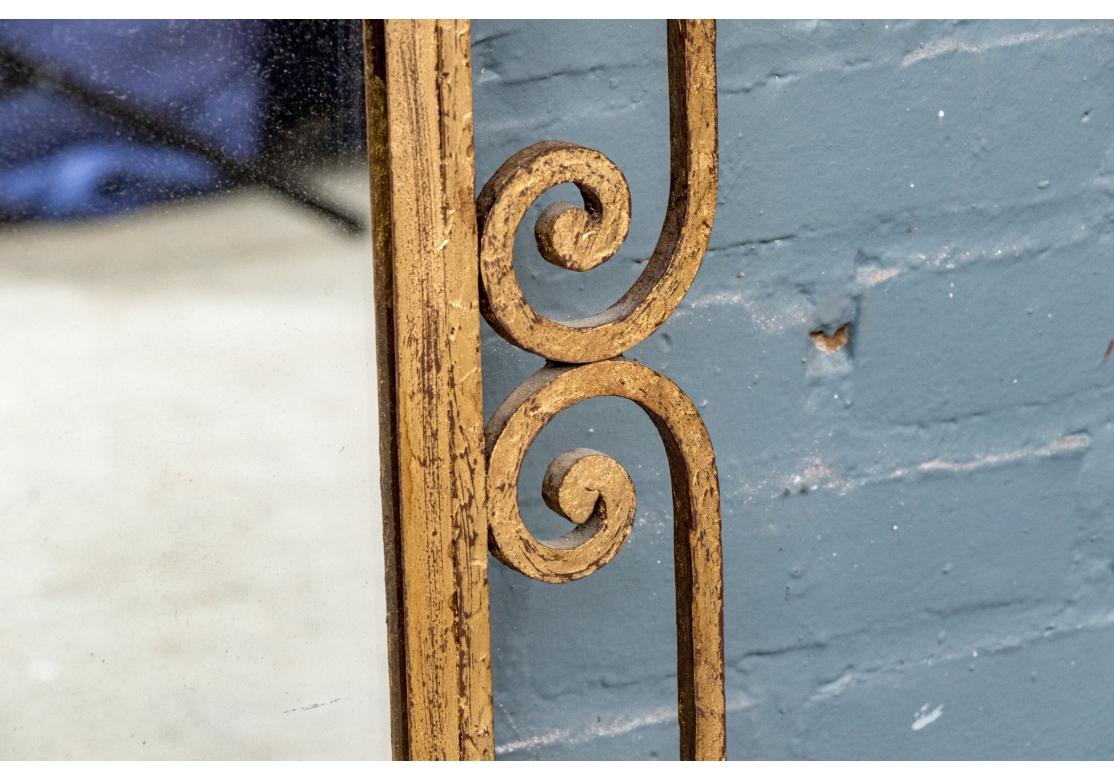 The mirror with an openwork frame with scrolled decoration around the center mirror plate. The iron frame is in an antiqued gilt finish. There are two hooks on the top of the back for hanging. 

Condition: Please review the detail photos. Various