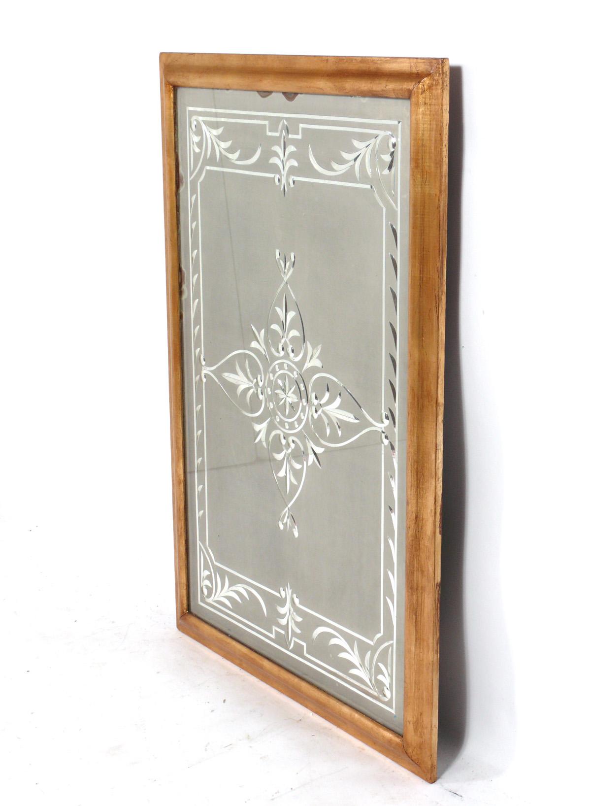 Élégant miroir gravé à cadre doré, américain, vers les années 1940. Il mesure 46 pouces de haut sur 31,75 pouces de large et conserve sa chaude patine d'origine sur le cadre doré et le verre miroir d'origine. 