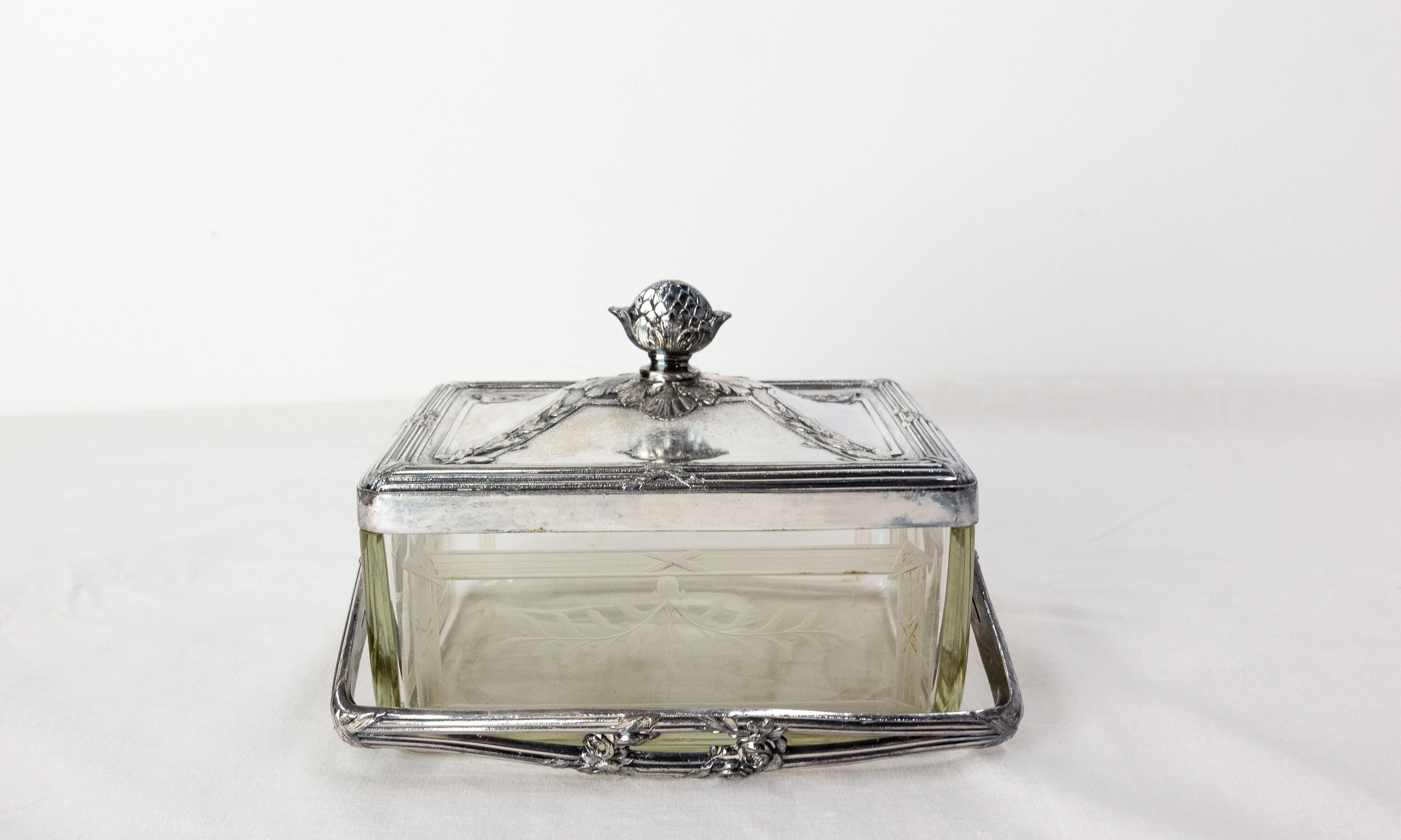 Petite boîte en verre gravé encadrée d'éther nickelé avec son couvercle assorti et une poignée.
La décoration de la boîte avec ses éléments végétaux, ses roses et sa pomme de pin sont typiques de la période Napoléon III.
Peut être utilisé comme un