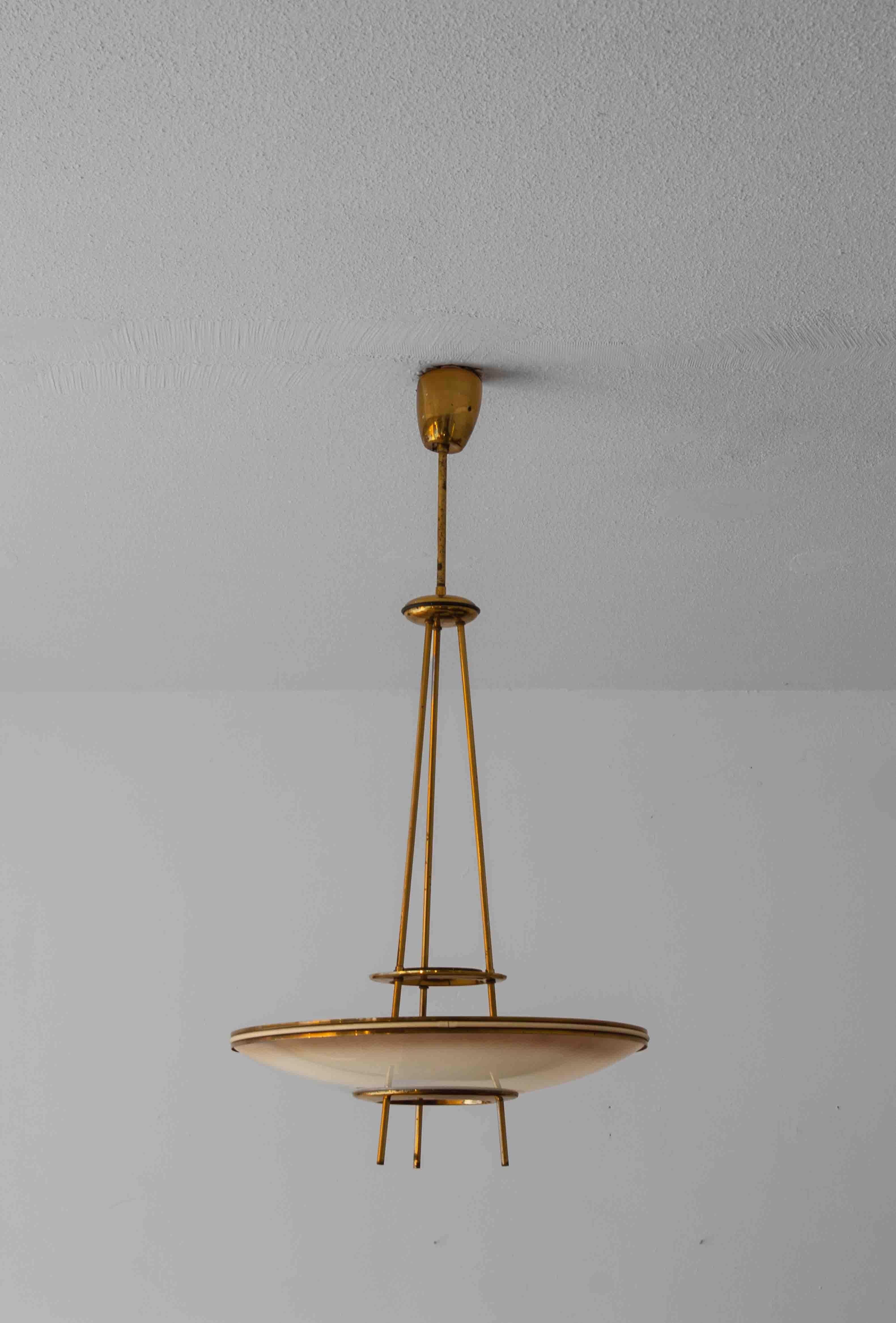Seltener Kronleuchter, entworfen von Pietro Chiesa für Fontana Arte in den 1950er Jahren. Diese Version hat einen halbkugelförmigen Opalglasdiffusor, der an drei Messingstäben mit eleganten strukturellen Details aufgehängt ist. Ursprünglich als