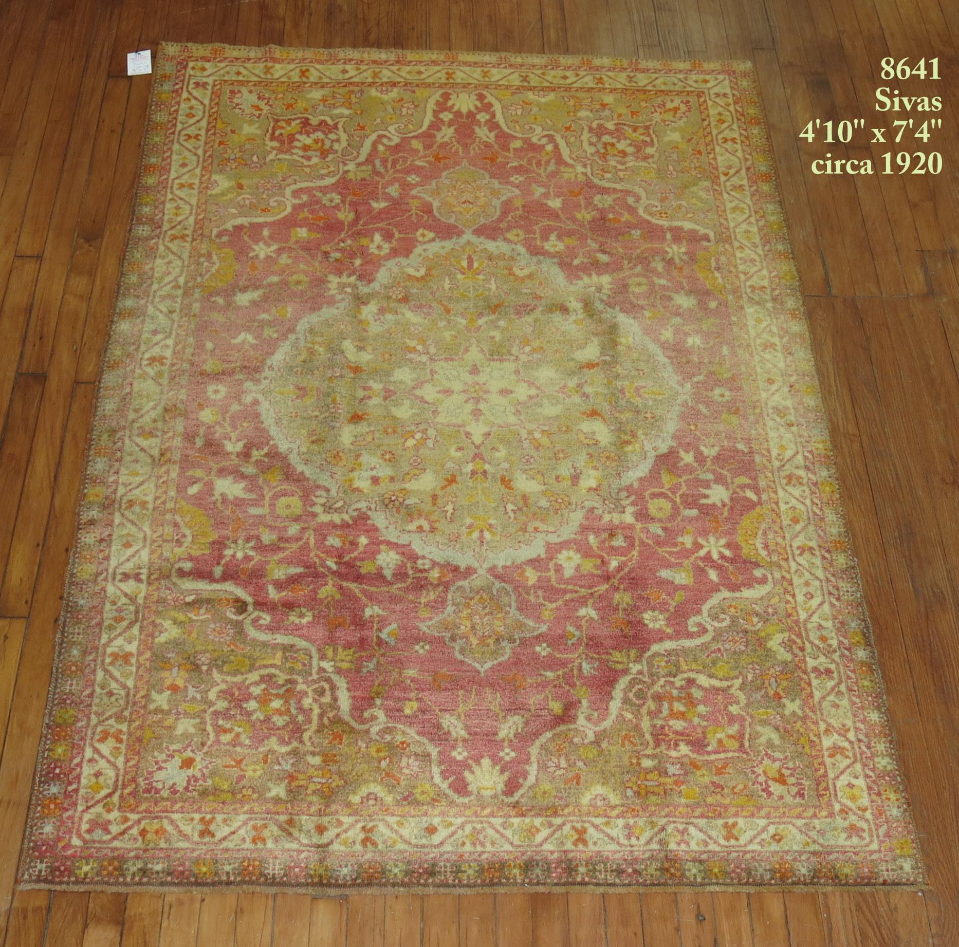 A superfine connoisseur caliber early century Turkish rug with an elegant medallion border motif in red pumpkin orange, brown, and green. 

Measures: 4'10'' x 7'4''.