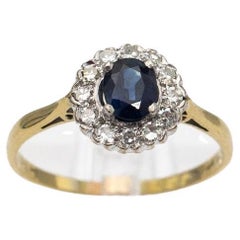 Elegant gold ring with sapphire surrounded by diamonds, 1940s.