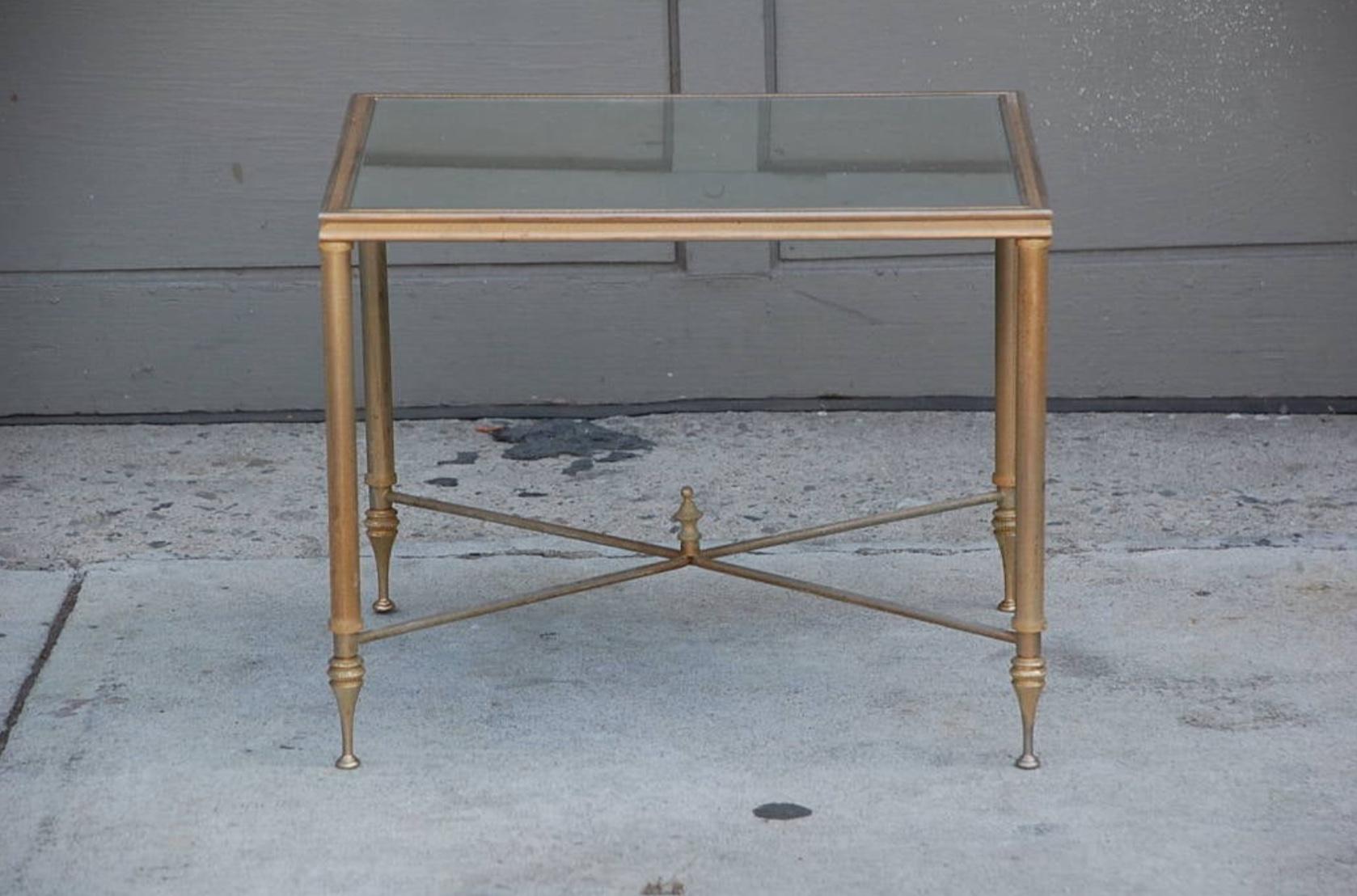Table d'appoint élégante en or avec verre miroir antique.