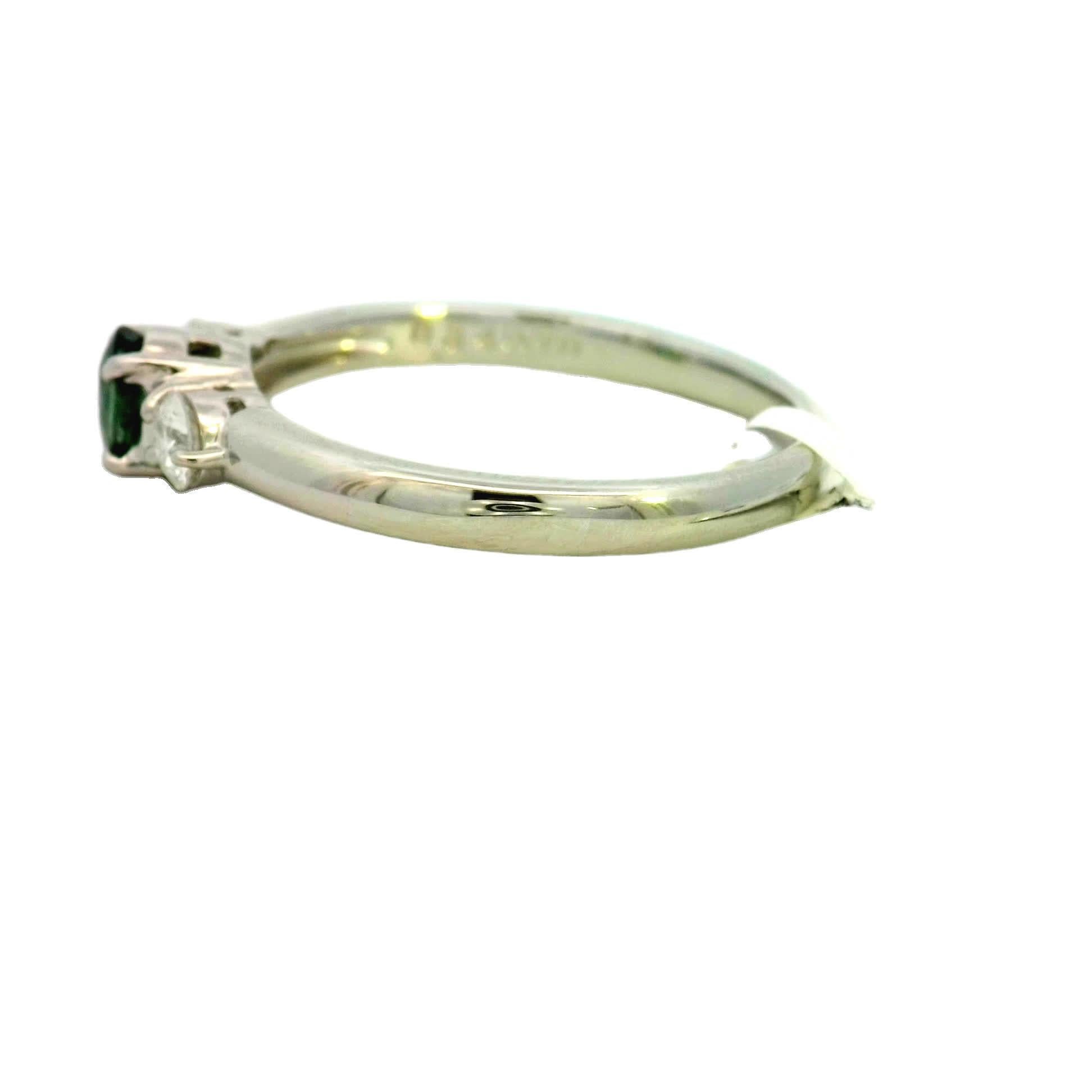 Discover the allure of this stunning green gemstone ring, designed to captivate and impress. The central oval green stone is beautifully complemented by two sparkling diamonds on either side, creating a harmonious balance of color and brilliance.