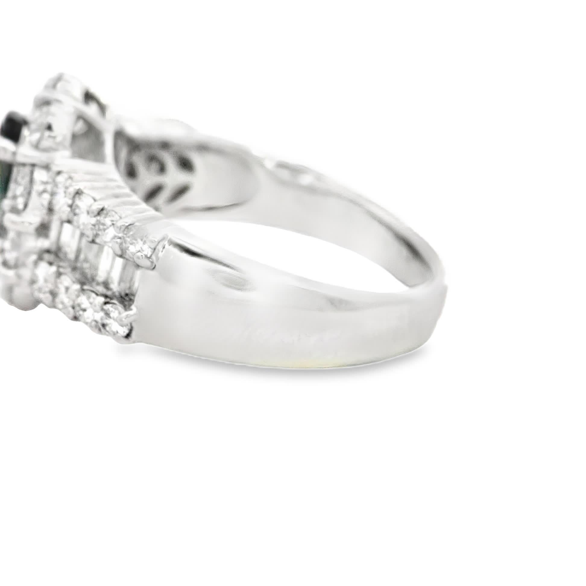 This stunning ring features a captivating green gemstone at its center, surrounded by a halo of sparkling diamonds. The intricate design showcases a blend of elegance and sophistication, making it the perfect accessory for any special occasion.