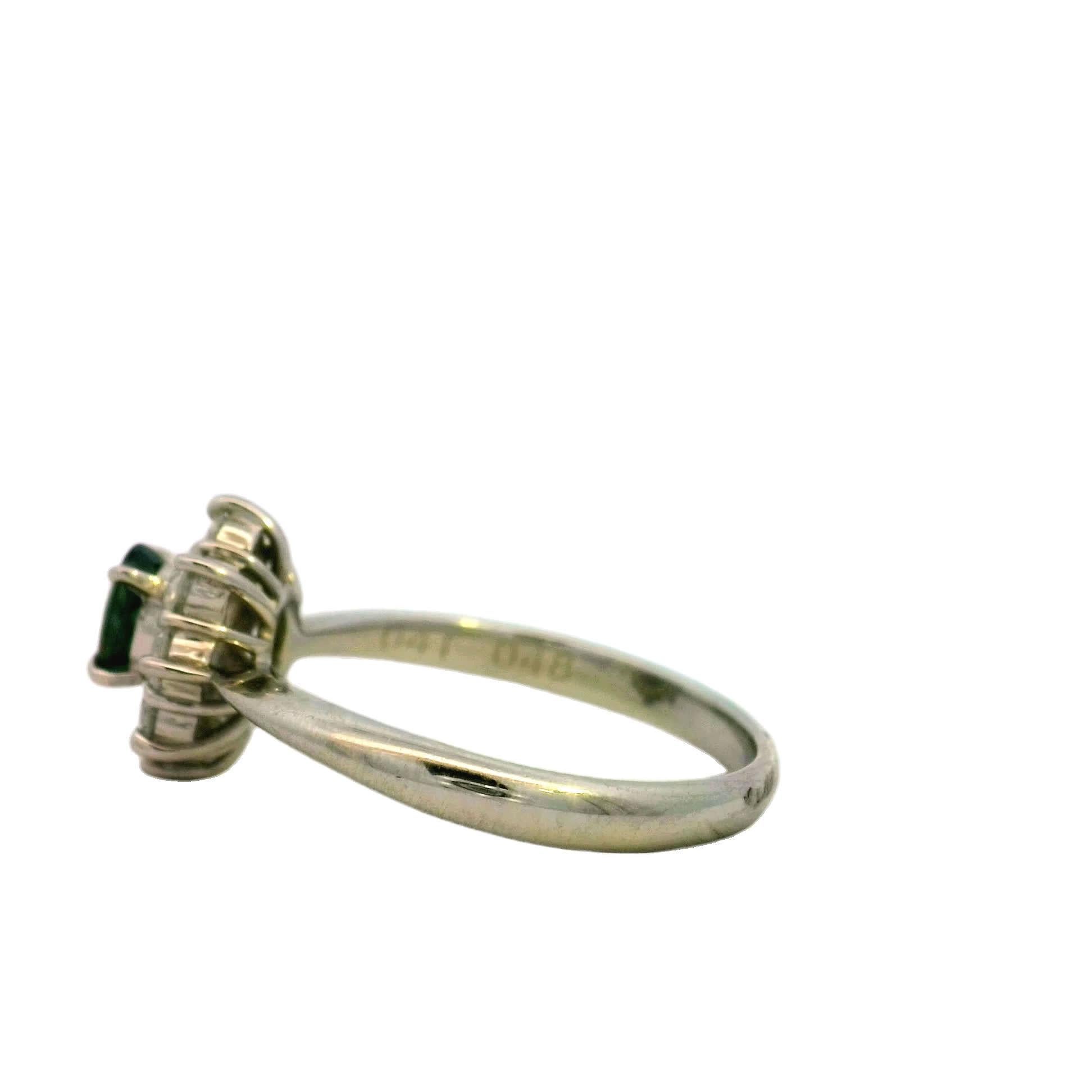 This stunning ring features a vibrant green gemstone at its center, surrounded by a halo of sparkling diamonds. Crafted with precision, it showcases a timeless design that is perfect for any occasion, whether it's an engagement or a special gift.