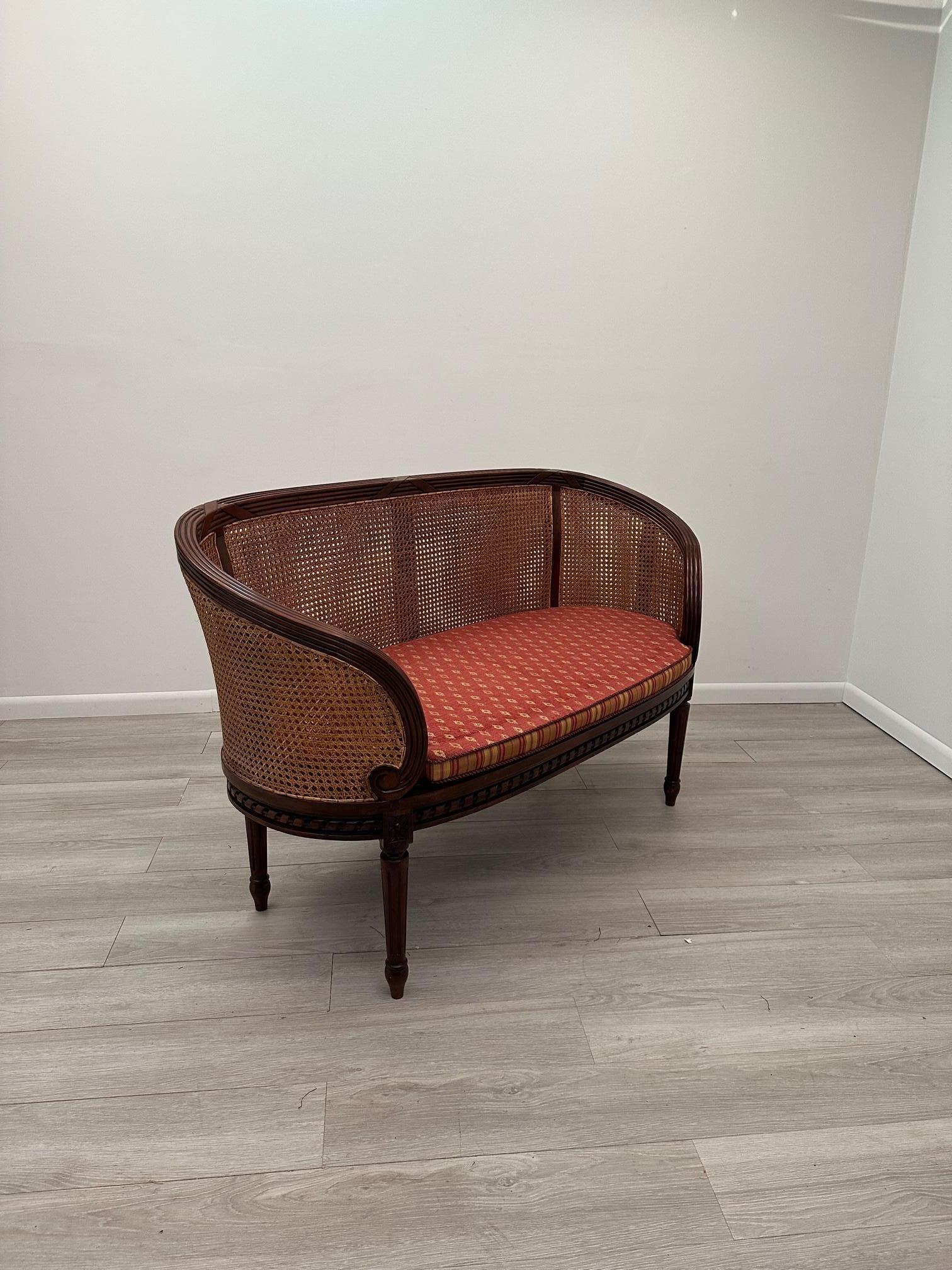 Elegant shapely hand carved mahogany loveseat having handsome caning, lovely curved back, and custom upholstered seat cushion.