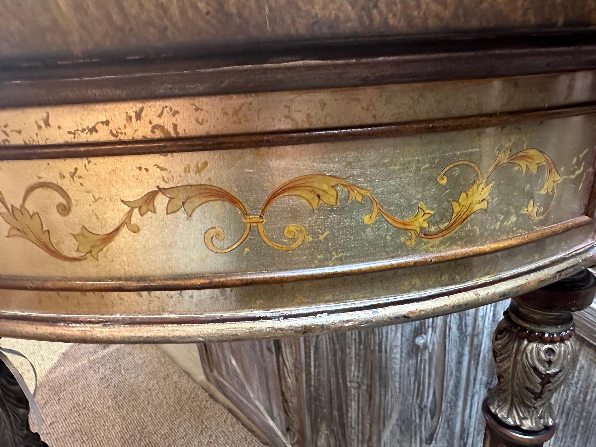 Dramatic Theodore Alexander hand painted demilune console with intricate details and lovely silver leaf and warm brown color palette.
One drawer
