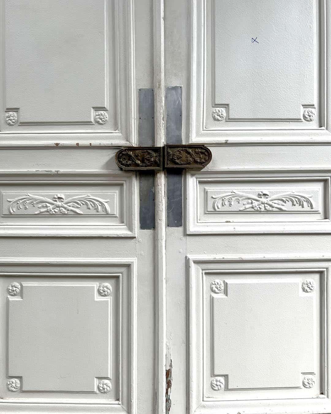 Questa raffinata porta a due battenti in stile Haussmann & Haussmann, che misura 149 × 254 cm, presenta splendidi pannelli modanati, delicate rosette floreali agli angoli e una ferratura ricca di dettagli. La sua finitura bianca e brillante si