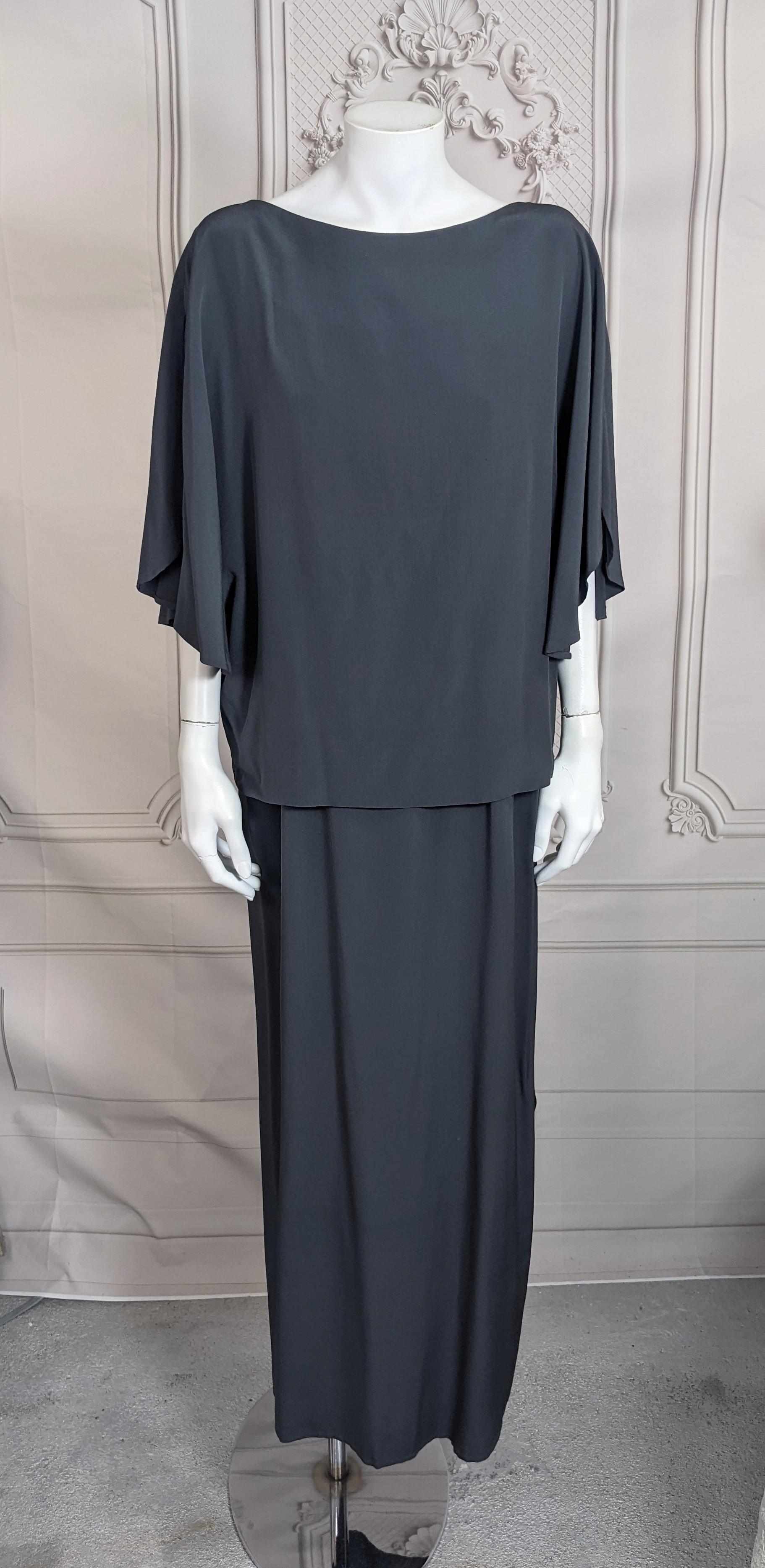 Elegant Madame Gres Anthracite Silk Crepe Ensemble from the 1970's. Simple ensemble with underdress and top. Top slips over head with button at neck and open sides. Easy bateau neckline with curved panels at shoulder which is repeated at left hem.