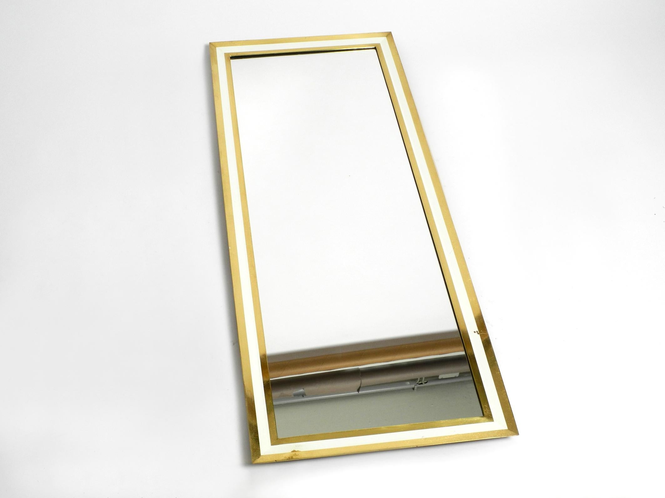 Very elegant heavy 1960s midcentury XXL brass wall mirror.
Manufacturer is Münchener Zierspiegel. With original label on the back. Made in Germany.
Great 1960s Minimalist design. Vertical to hang.
The entire frame is solid heavy brass, slightly