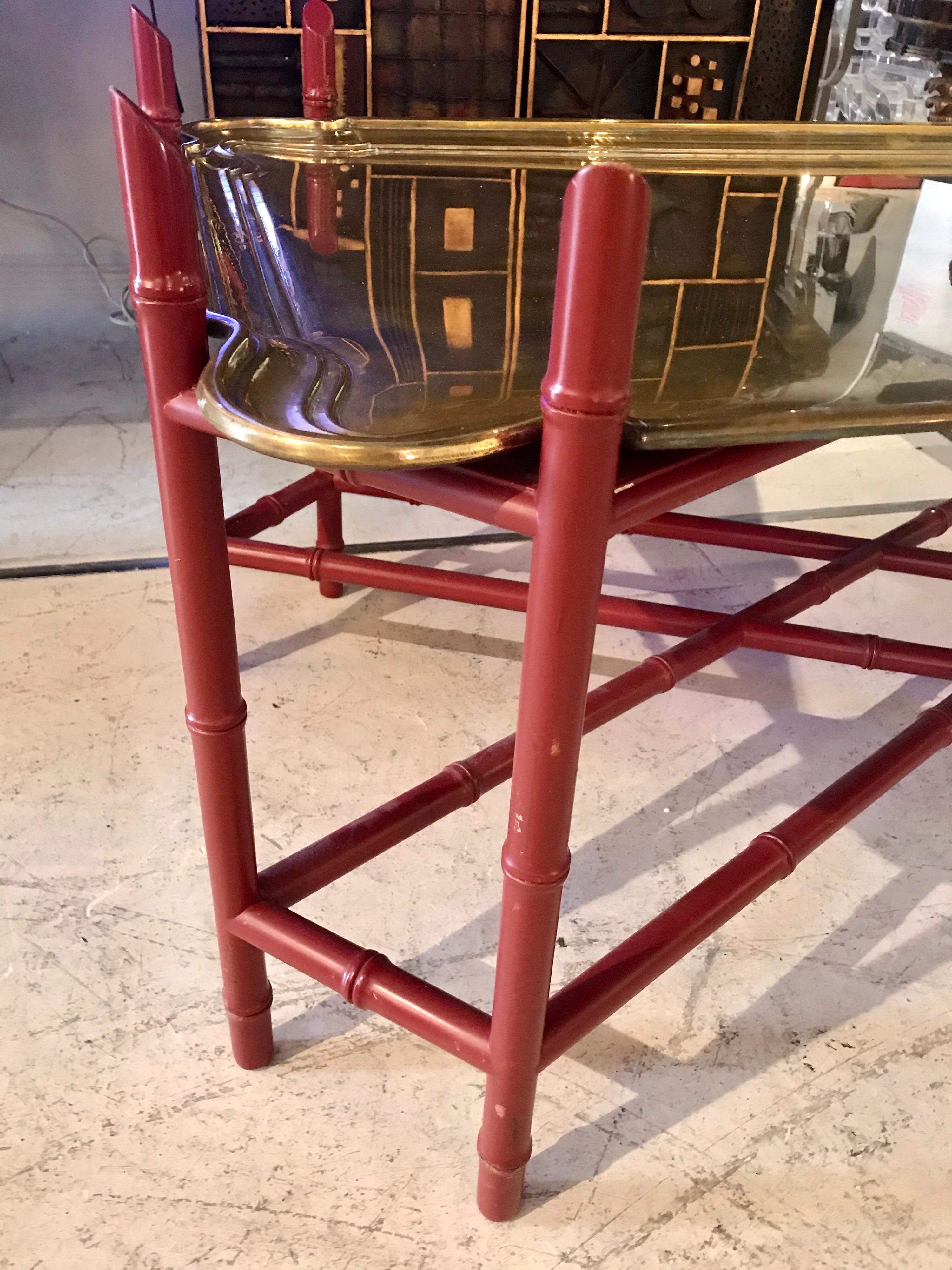 Rich looking transitional coffee table having a heavy super high quality (1/2 inch thick) brass scalloped rectangular tray and handsome faux bamboo red lacquered base. The height to top of the tray is 18 inches. The bamboo frame extends above the