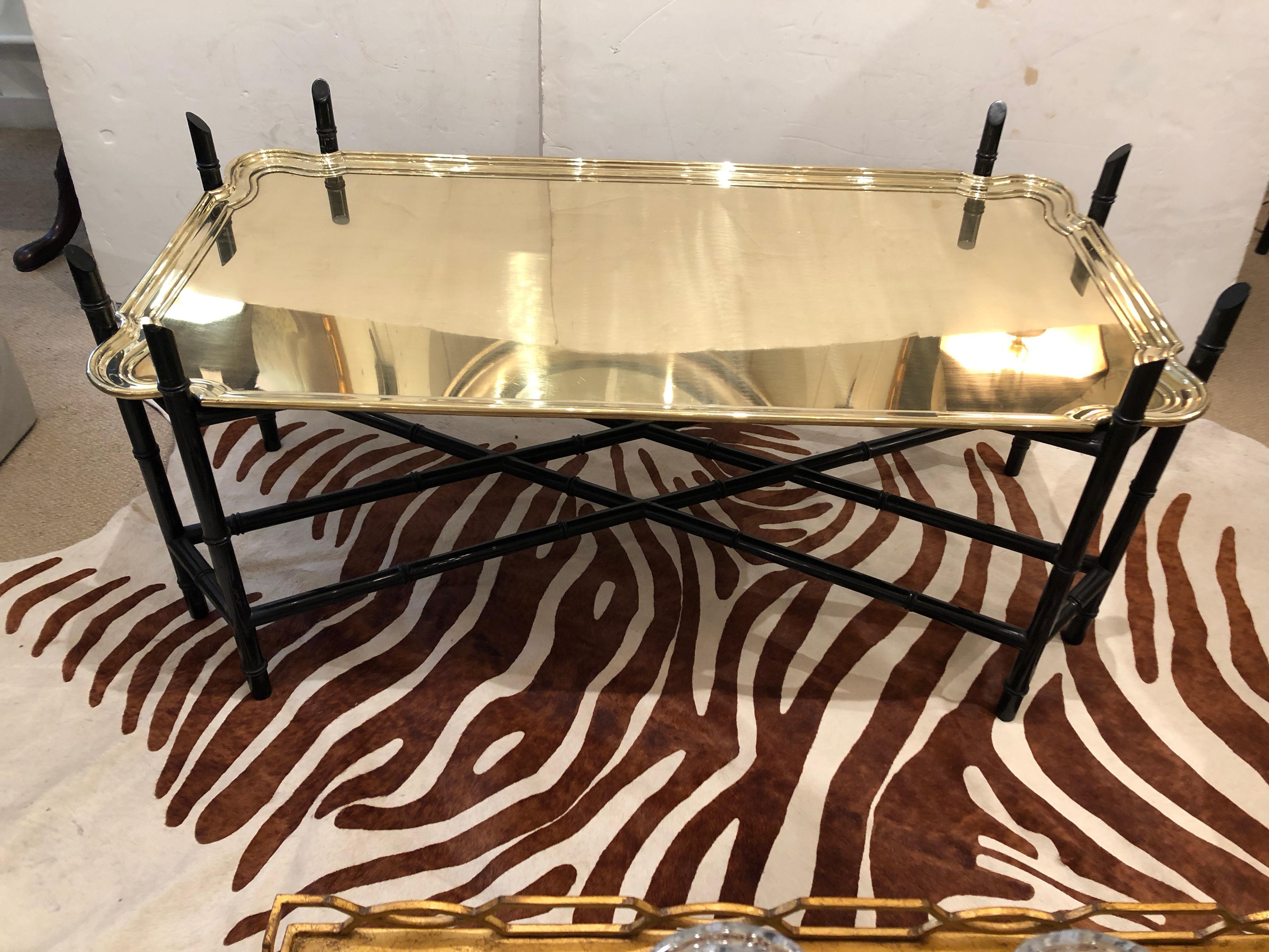 Rich looking transitional coffee table having a heavy super high quality (1/2 inch thick) brass scalloped rectangular tray and handsome faux bamboo ebonized base. The height to top of the tray is 18 inches. The bamboo frame extends above the tray.