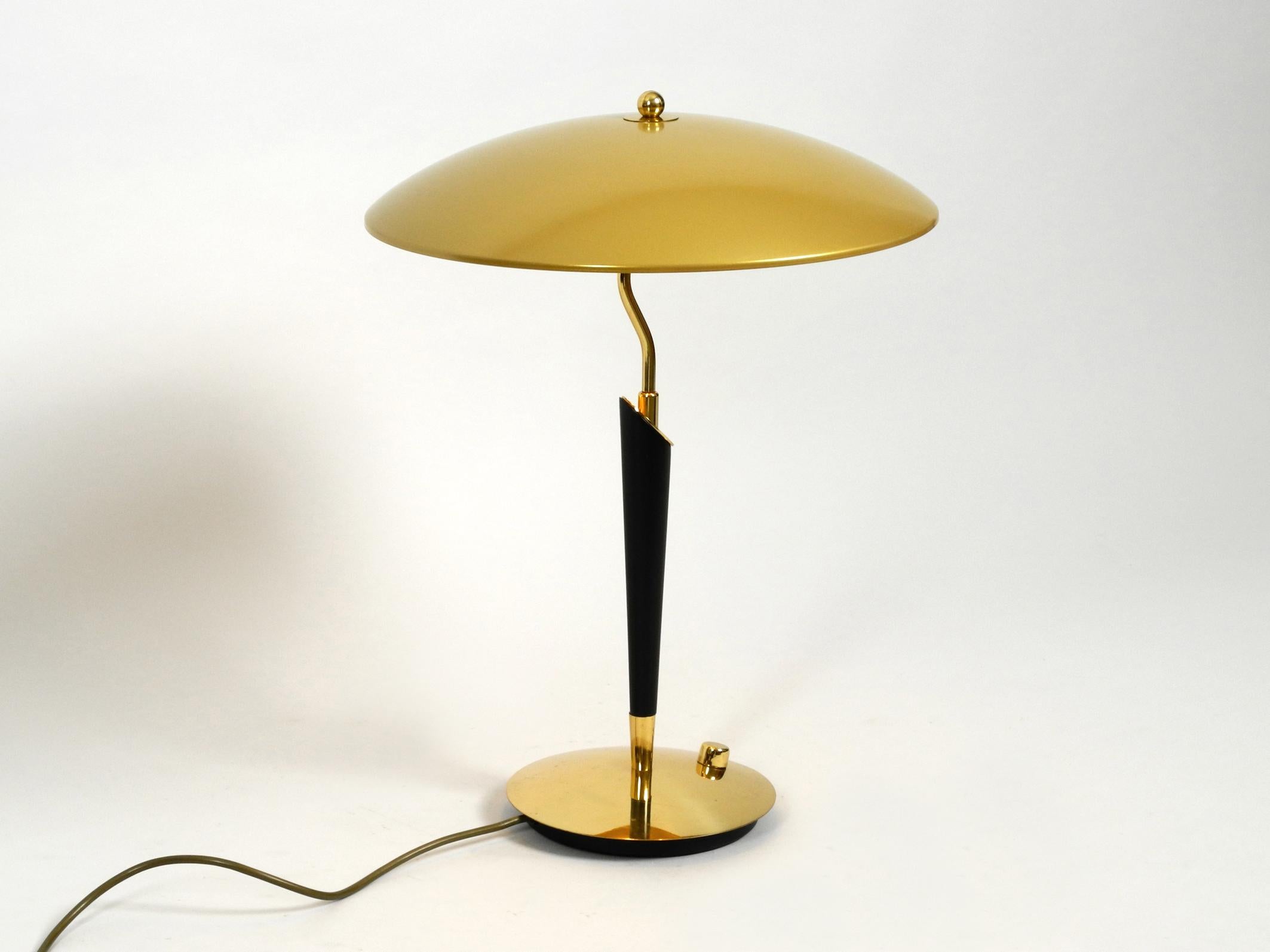 Very elegant heavy extra large brass table lamp from Hillebrand. Manufactured in the 1960s.
Very large version with a huge shade and heavy foot.
Beautiful Mid Century design made entirely of brass with three E14 sockets for 40W each.
The switch