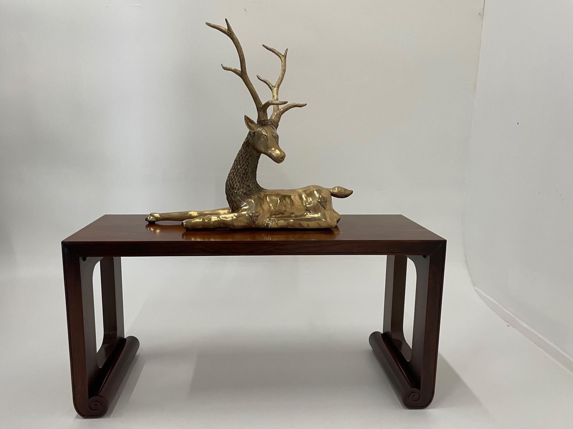 Impressive and elegant monumental polished brass reclining stag table top sculpture having great attention to detail.