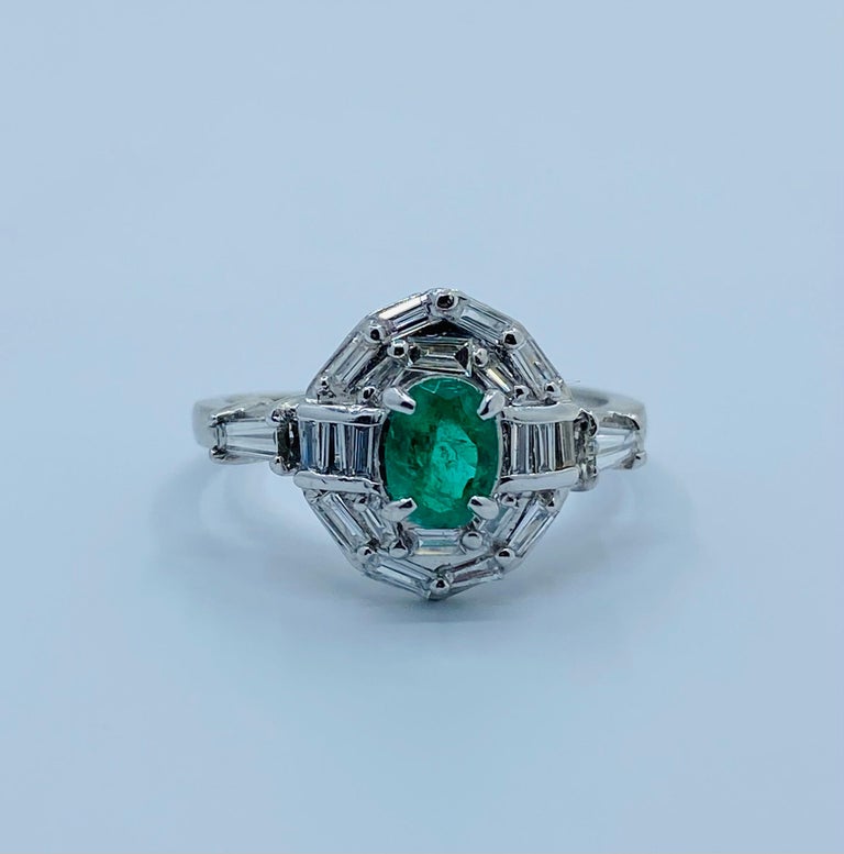 Beautiful estate oval cut intense green natural Columbian emerald is prong set in platinum and surrounded by a double halo of baguette cut diamonds. Ring is further accented by a tapered baguette diamond on each side.

Emerald measures 5.86 mm high