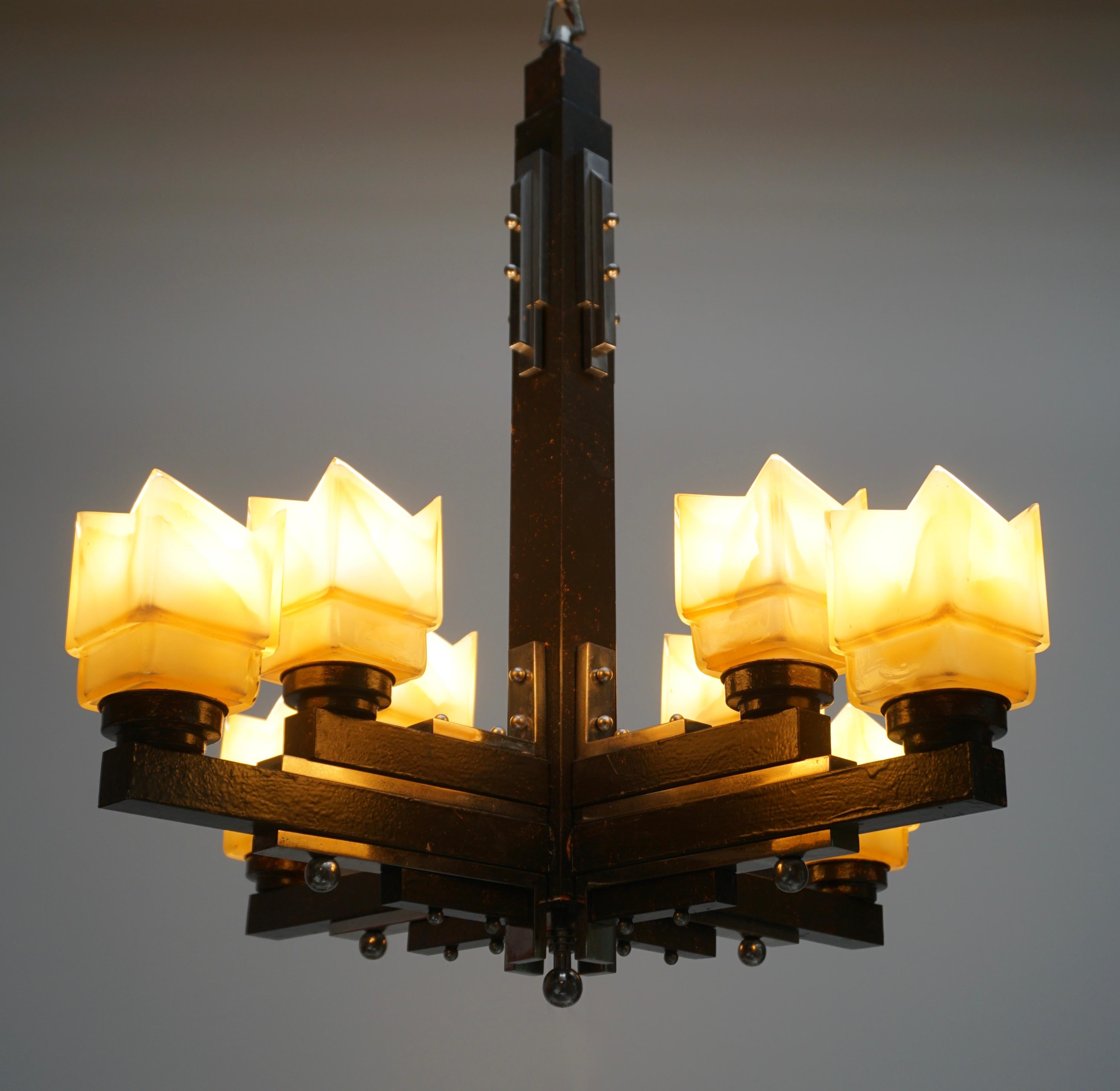 This elegant French Art Deco chandelier is composed nickeled bronze, wood and eight orange frosted glass shades.
The light requires eight single E27 screw fit light bulbs (60Watt max.) LED compatible.
Measures: Diameter 68 cm.
Height fixture 75