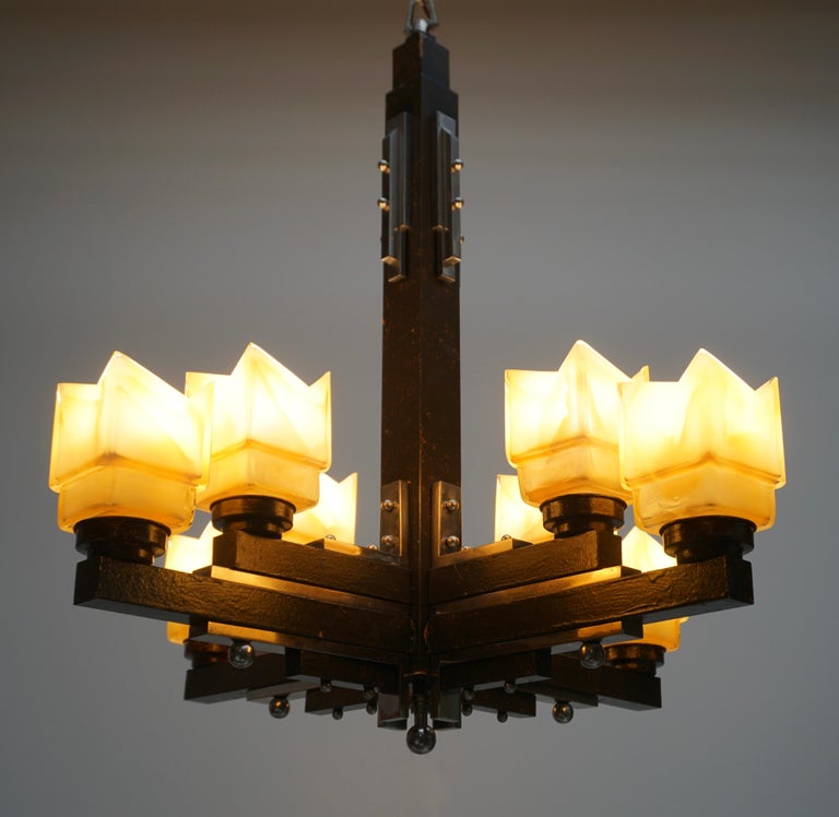 This elegant French Art Deco chandelier is composed nickeled bronze, wood and eight orange frosted glass shades.
The light requires eight single E27 screw fit light bulbs (60Watt max.) LED compatible.
Measures: Diameter 68 cm.
Height fixture 75