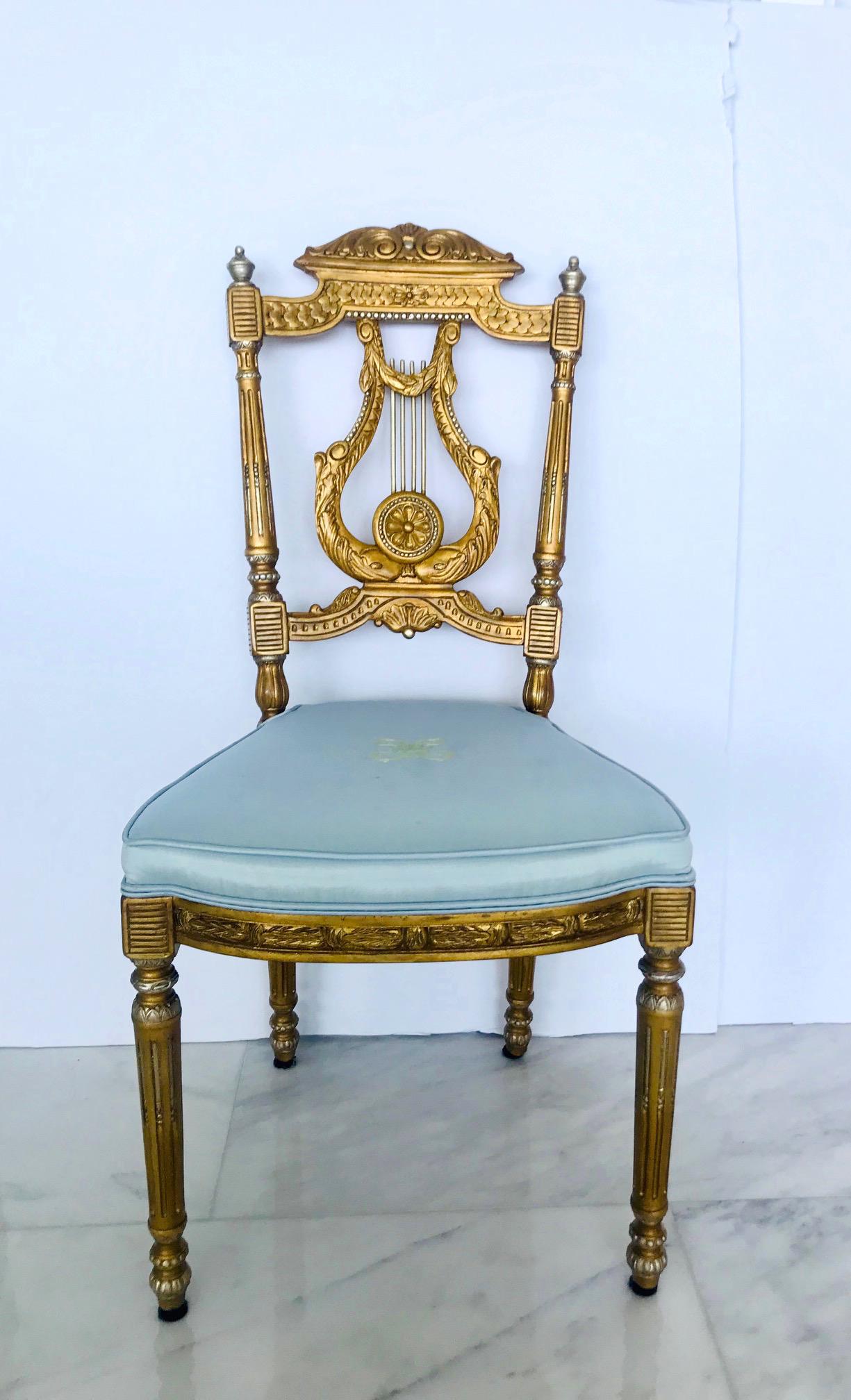 Beautiful salon chair or accent chair with neoclassical designs. Made of hand carved wood finished in antique gold leaf with silver leaf accents. The chair features a scrolled pediment top with carved ornamental designs throughout and with an